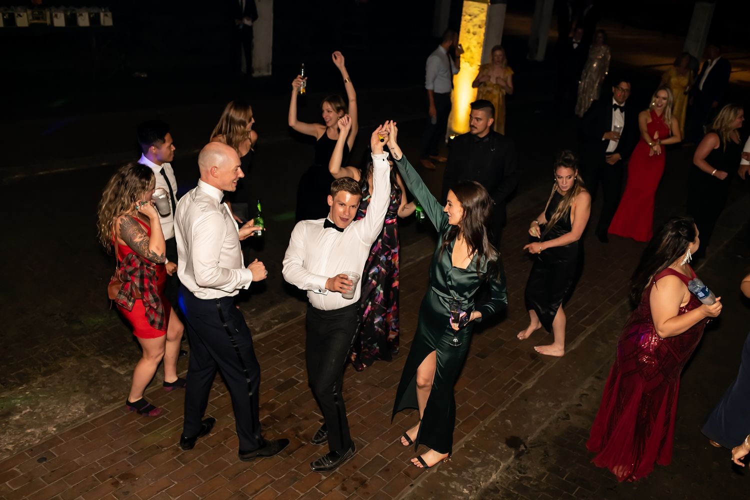 People dancing and socializing at a dimly lit indoor party or celebration event.