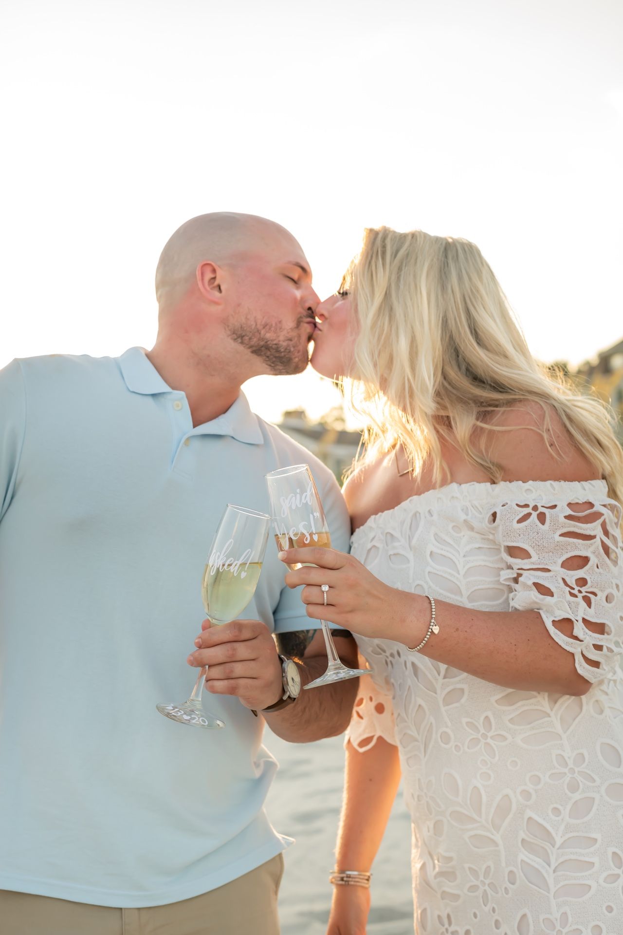 A couple sharing ice cream cones at sunset in casual summer attire creates a sweet romantic moment.