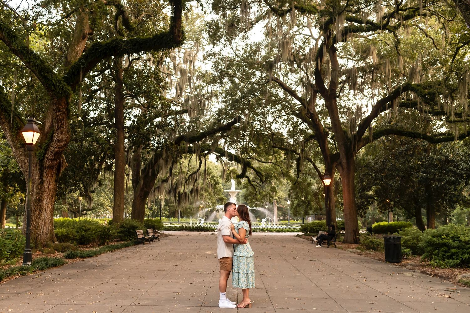 A romantic pathway under Spanish moss-draped oak trees in a serene Southern garden setting.