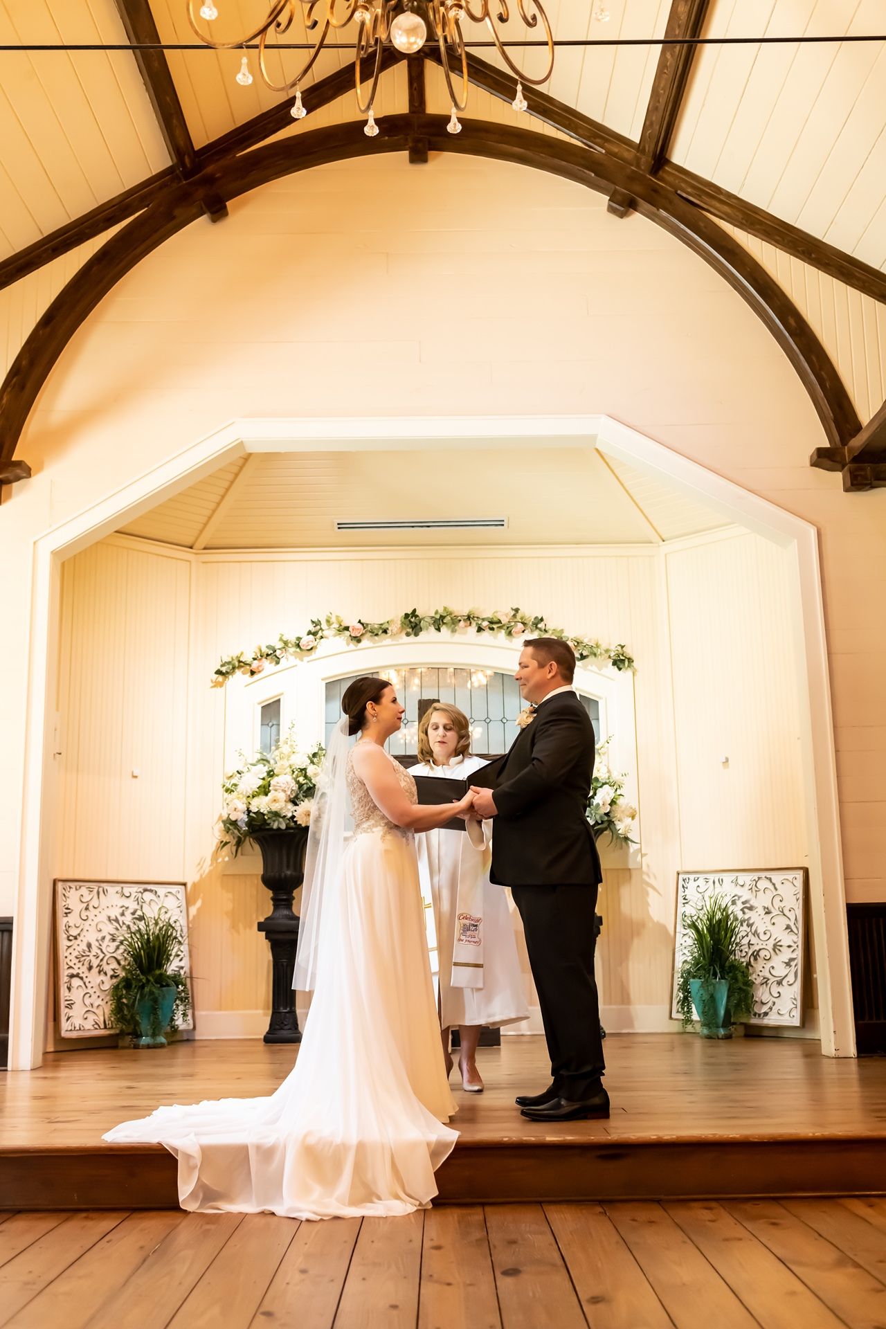 A series of wedding ceremony photos in a rustic chapel with wooden floors and exposed beams.