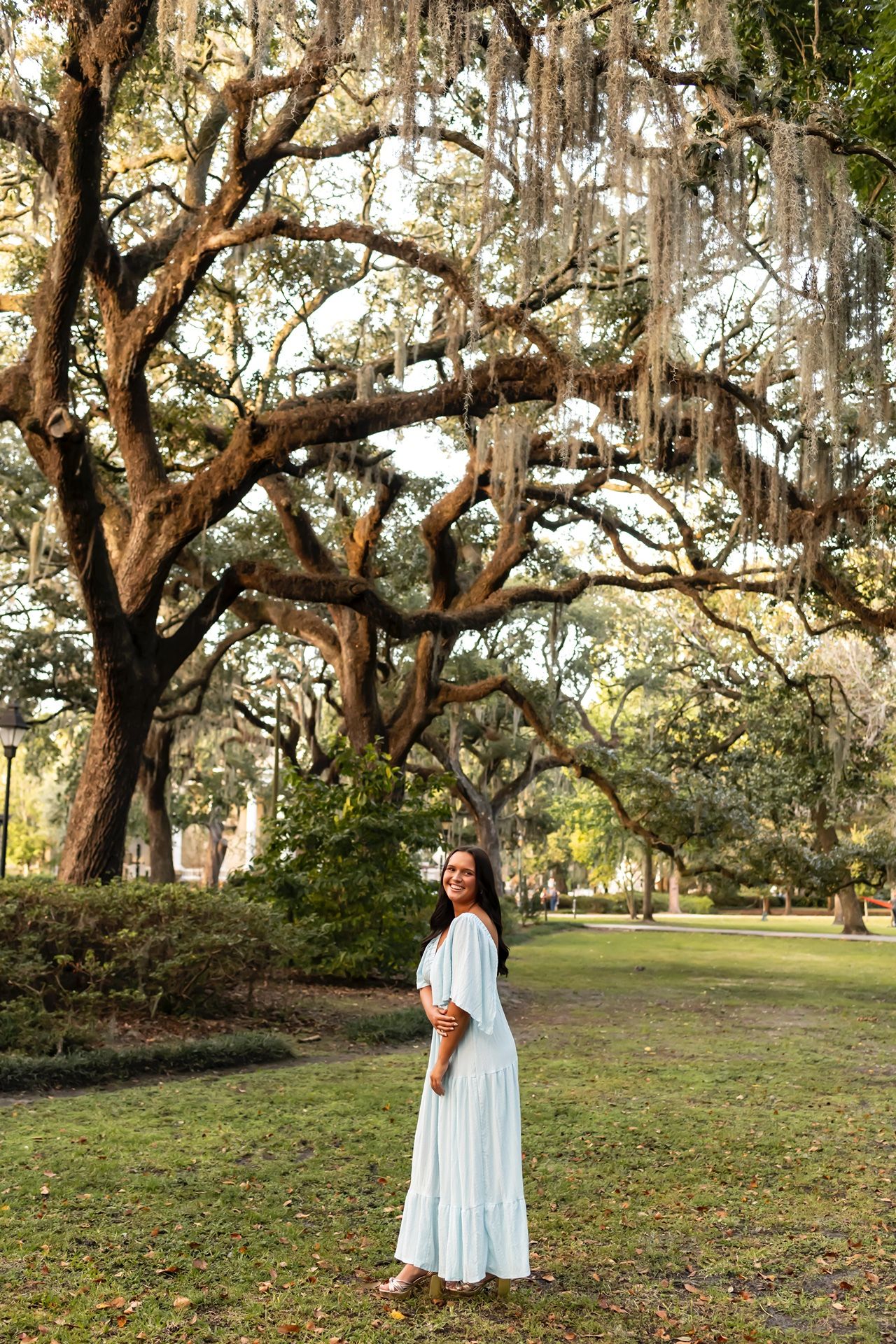 Four serene outdoor photos featuring someone in a flowing white dress under majestic oak trees draped with Spanish moss.