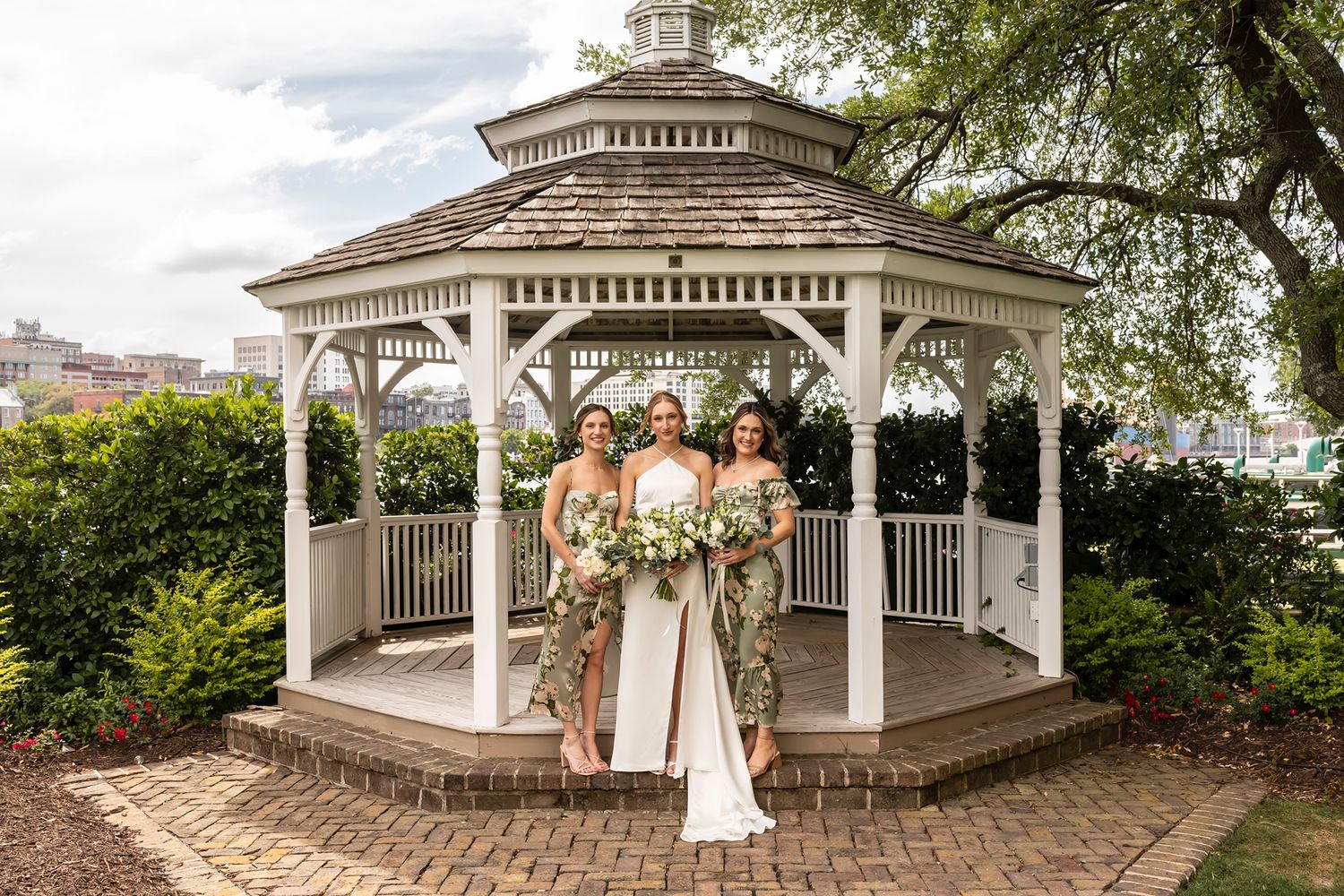 Wide angle panoramic view of a classic white garden gazebo decorated for an outdoor wedding.