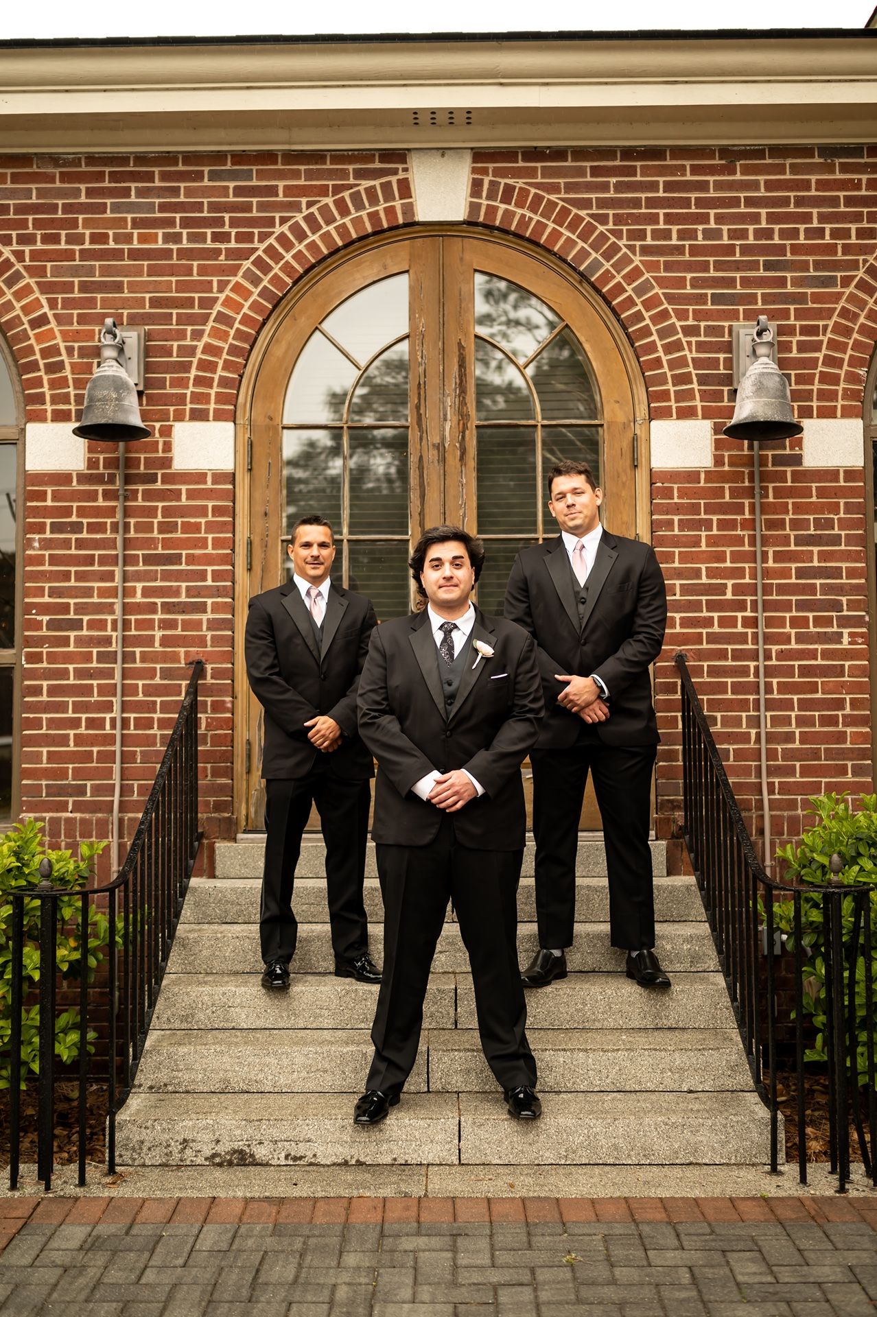 Four images showing people in formal black suits standing on stone steps in front of a traditional brick church building.