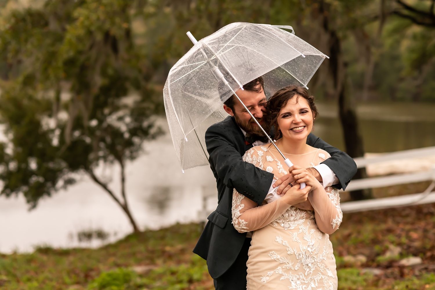 A couple embraces joyfully outdoors while sharing intimate and candid moments during their wedding photo session.