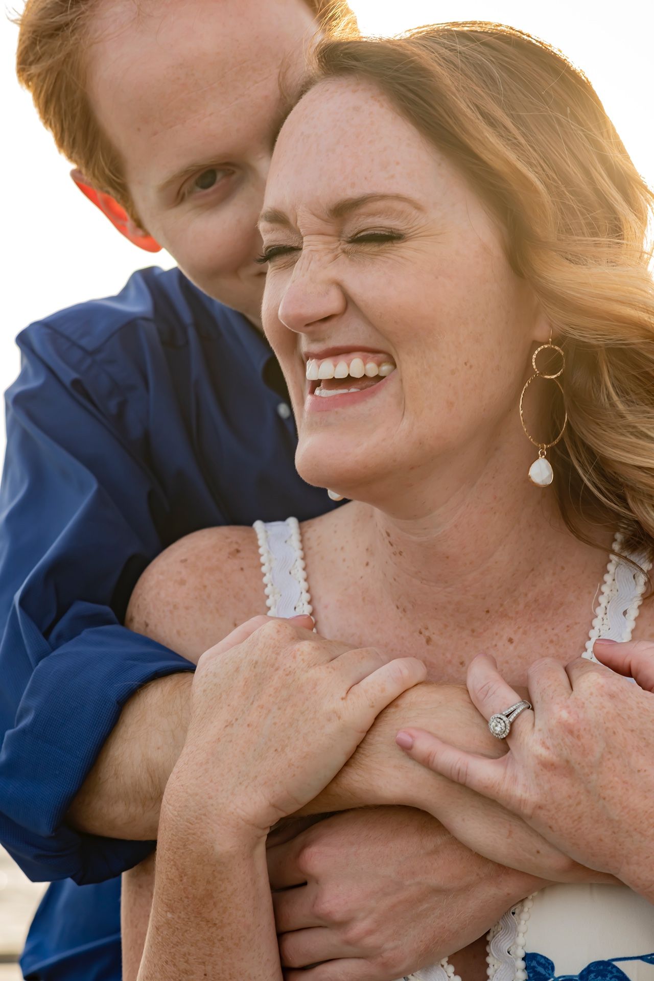 A couple shares intimate laughter and embraces in a heartwarming sequence of candid engagement photos.