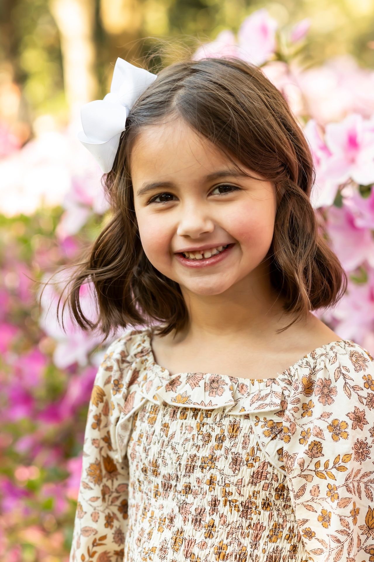 Floral backdrop frames joyful portrait sequence with pink azaleas in bloom.