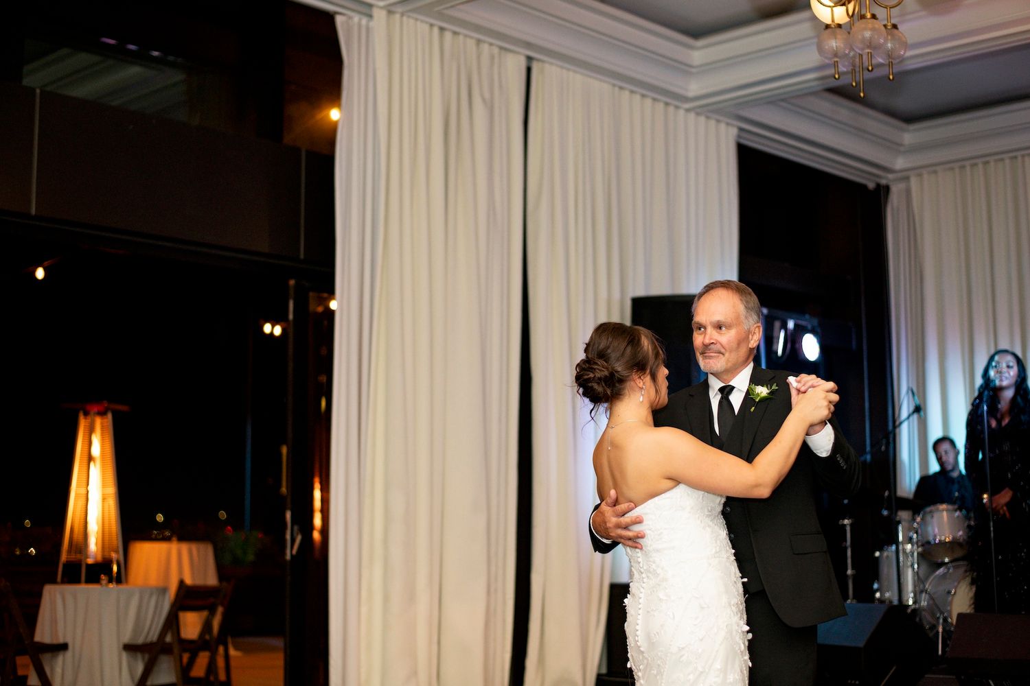 A couple shares a romantic dance together during their wedding reception in an elegant ballroom setting.