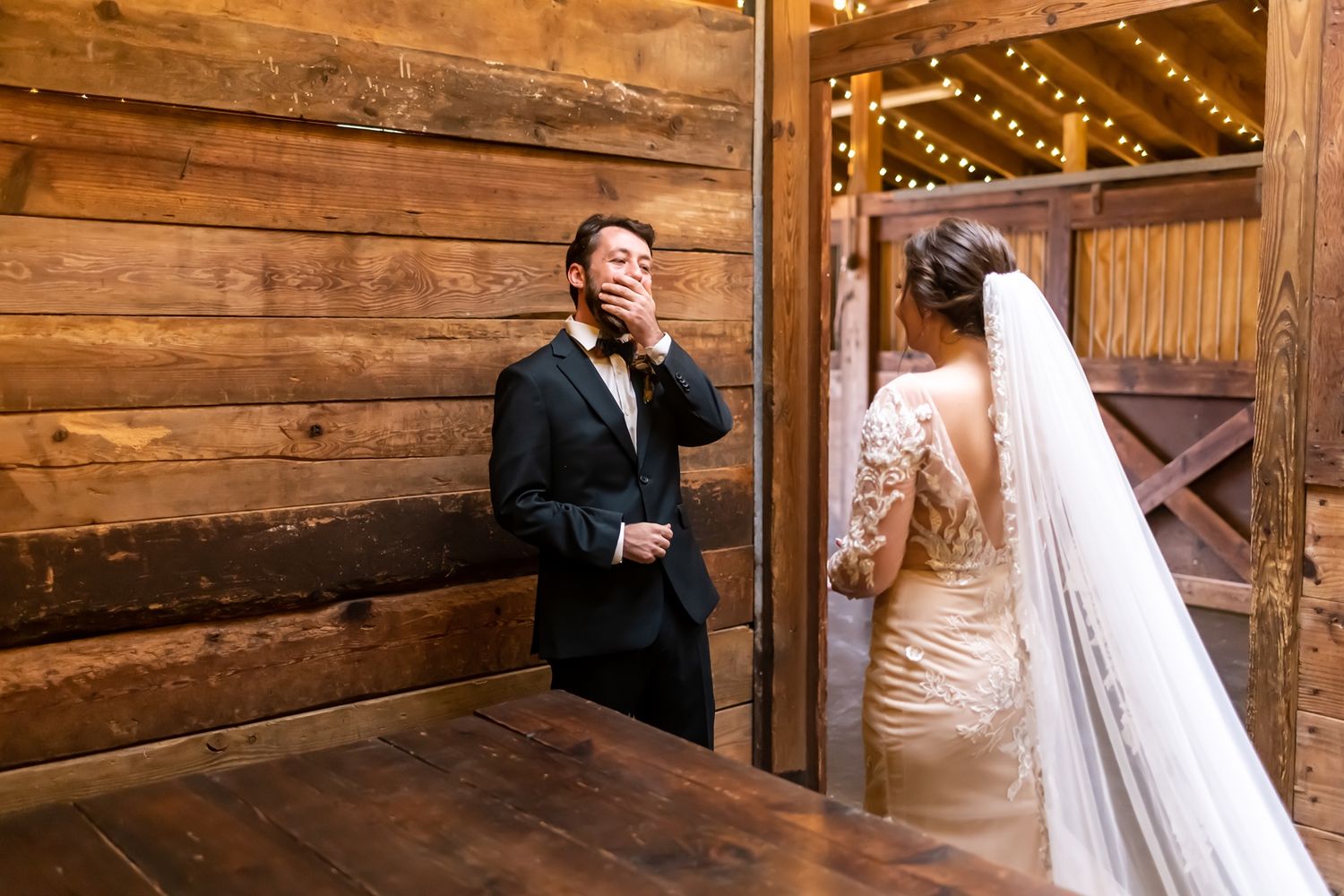 A couple shares an intimate moment in a rustic wooden barn setting.
