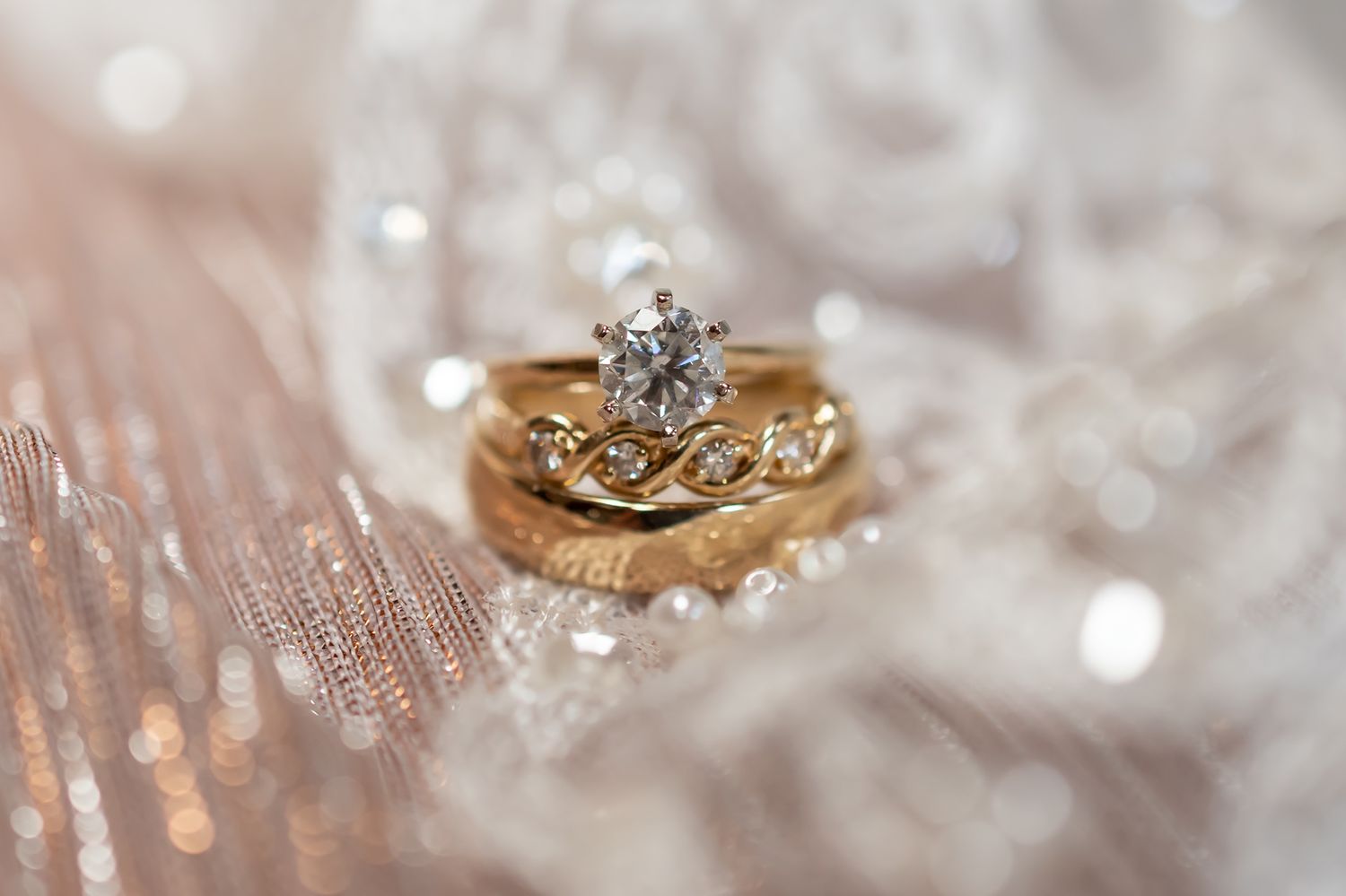 Close-up macro photo of sparkling diamond engagement rings with delicate details and bokeh background effects.