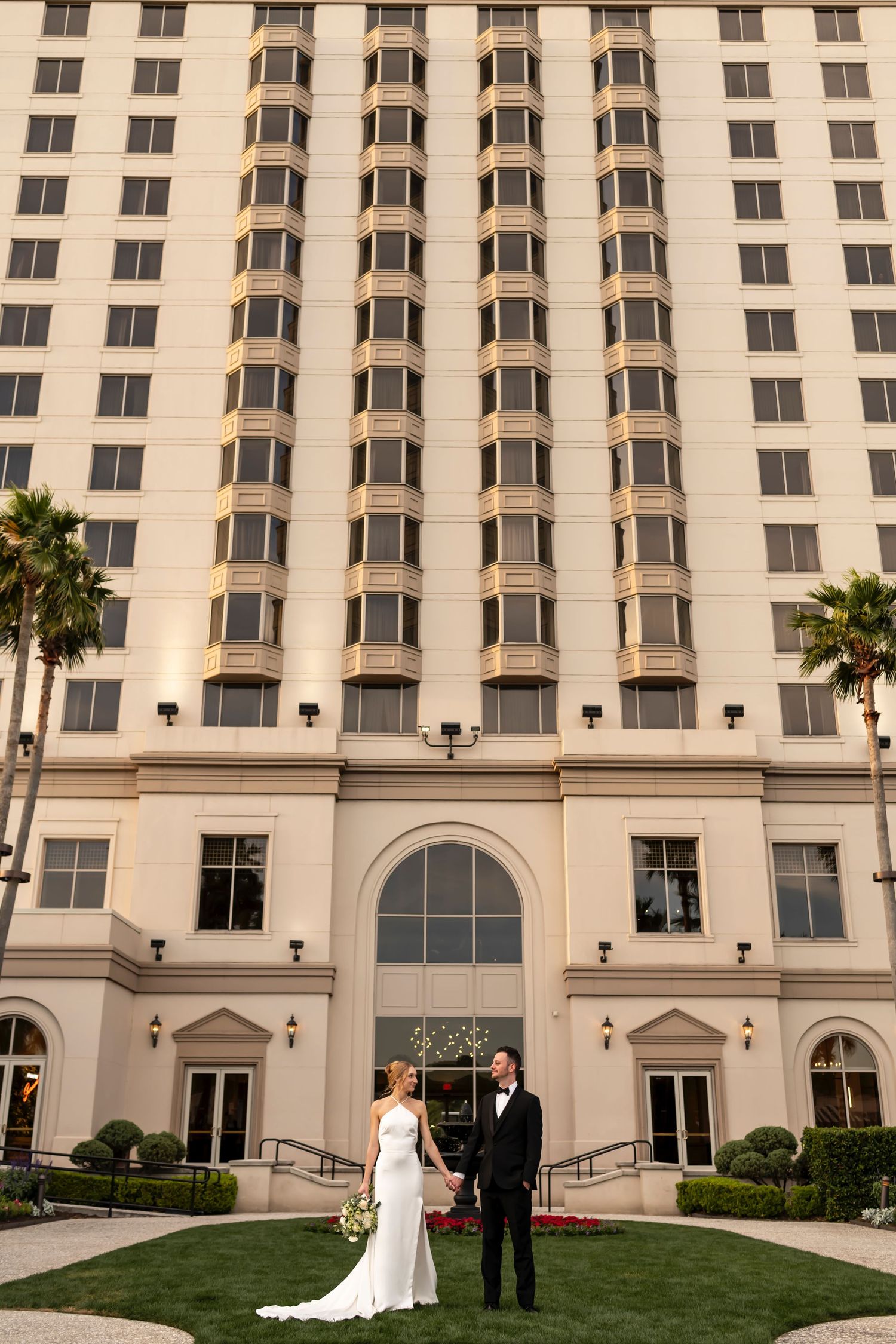 Bride and Groom pose in from of The Westin Savannah Harbor in Savannah, Georgia.
