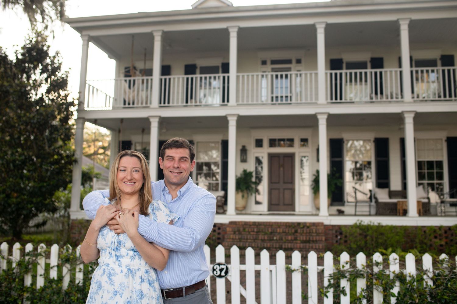 A series of five photos showing the exterior of a white farmhouse with a wrap-around porch and white picket fence.