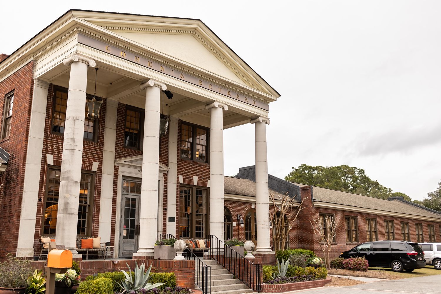 Stately brick building with imposing white columns and Greek Revival portico entrance features traditional colonial architecture.