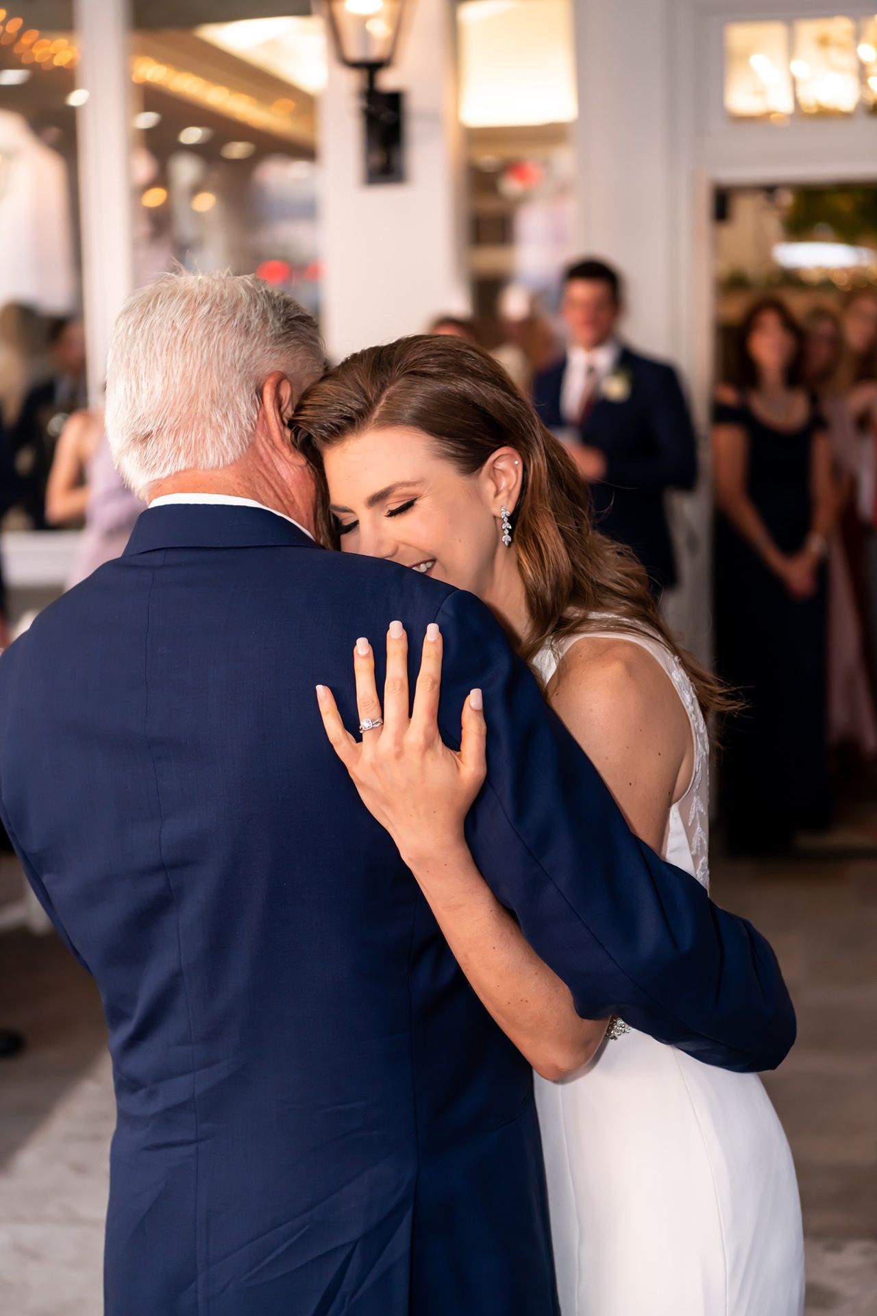 A heartfelt father daughter dance moment at a wedding reception shows a tender embrace on the dance floor.