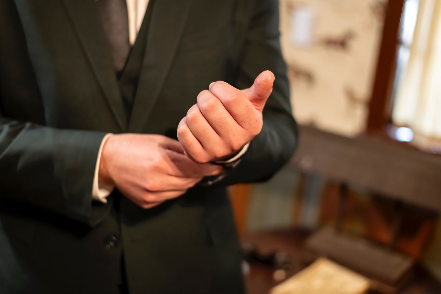 Several hands adjusting neckties and formal wear during event preparation.