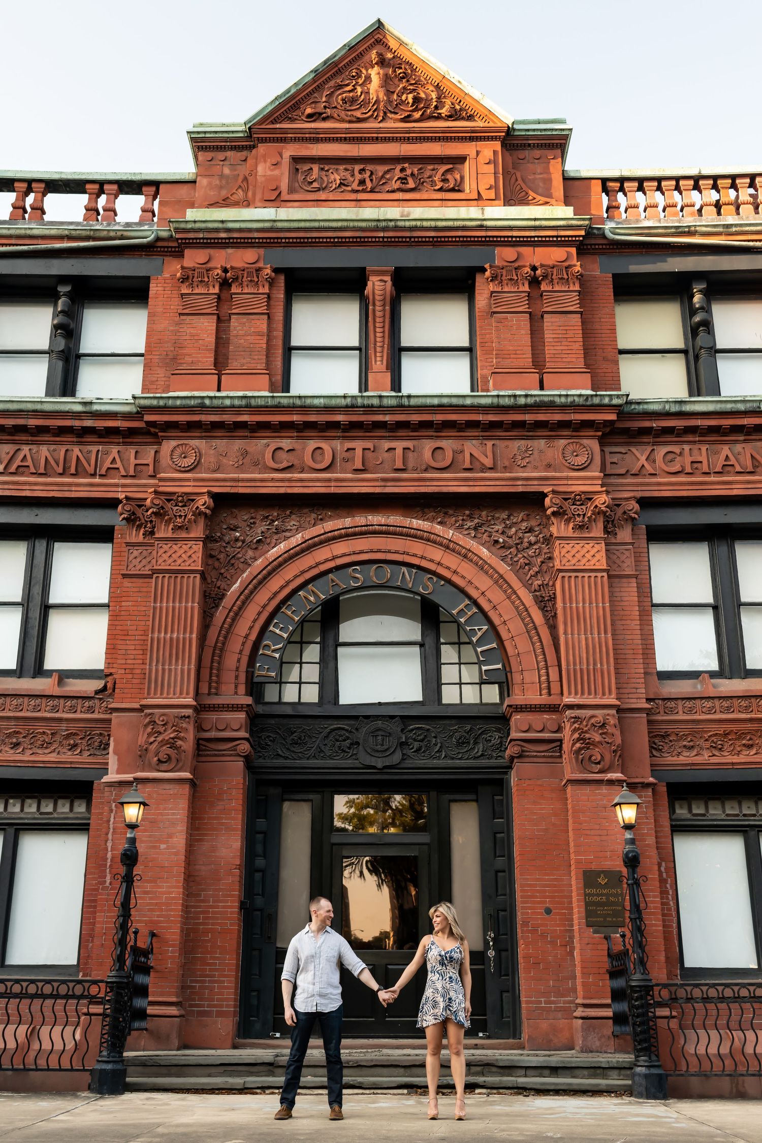Historic red brick building with arched entrance and ornate terracotta details at the Savannah Cotton Exchange in Georgia.