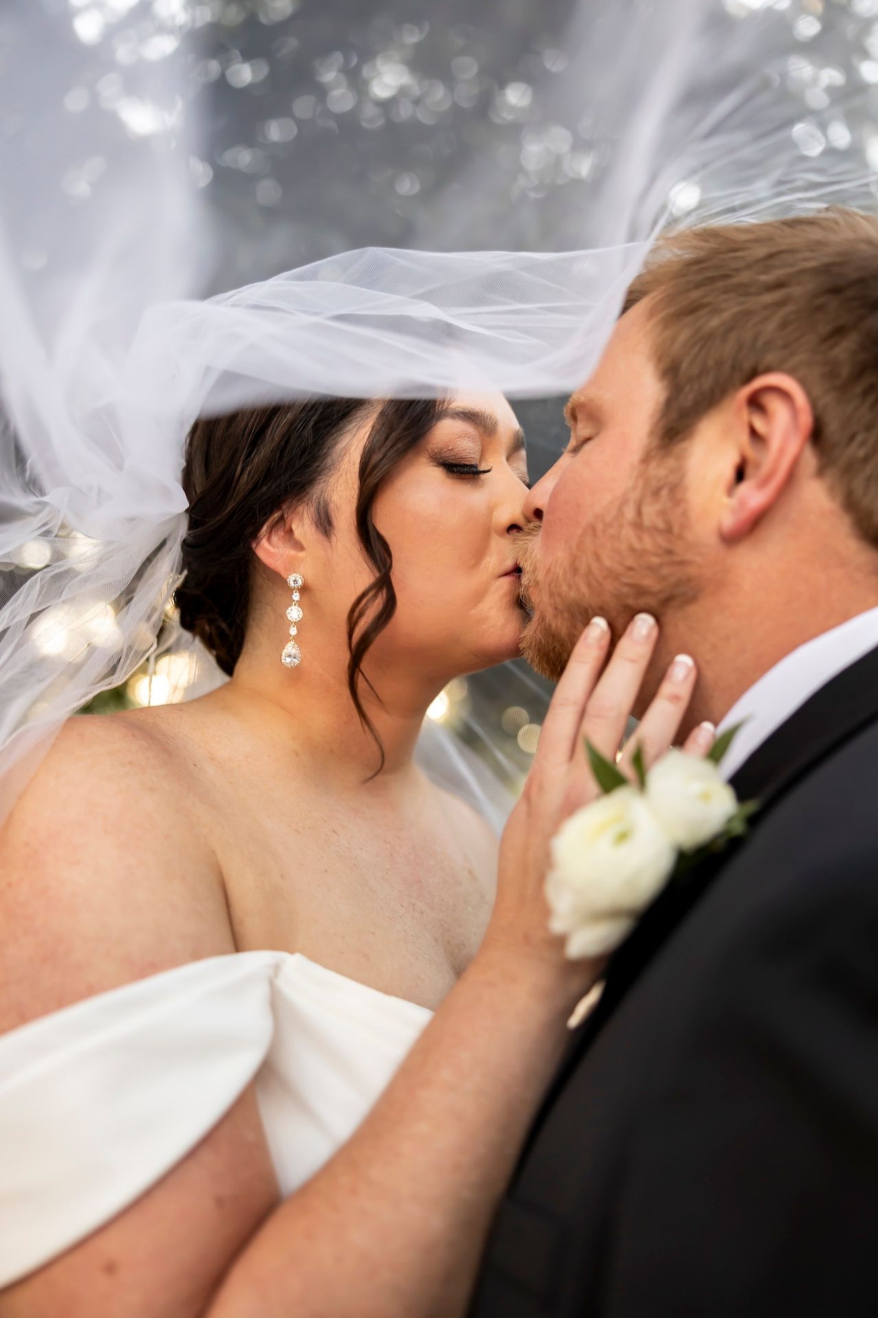 A series of romantic wedding kiss photos captured in soft focus with delicate veil and floral details.