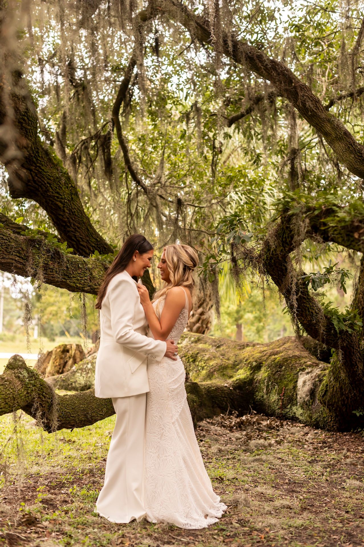 A romantic wedding photo session under a majestic oak tree draped with Spanish moss in a dreamy natural setting.