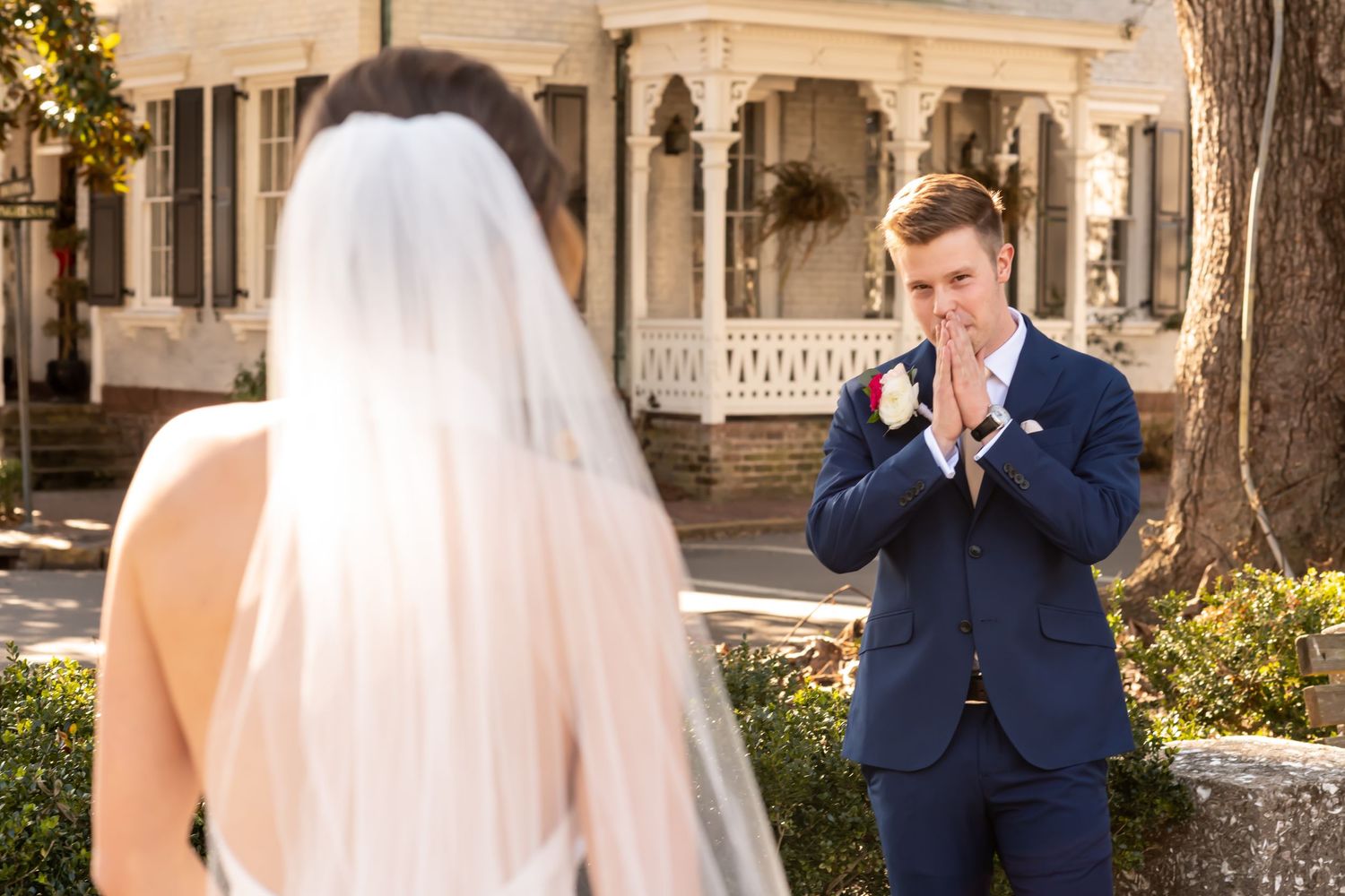 Emotional first look moment between couple on their wedding day at a vintage home with white porch and columns.