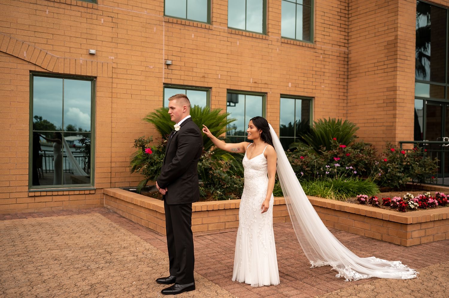 A collage of four wedding photos showing emotional first look moments outside a brick building.