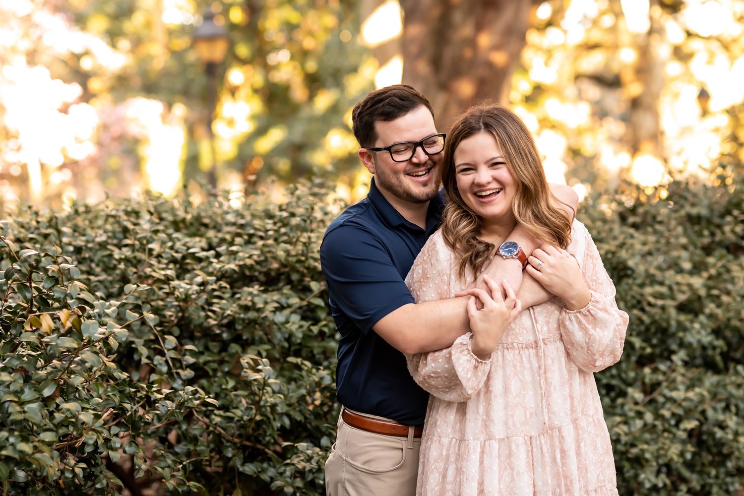 A parent and child share tender moments together in an outdoor garden setting during golden hour lighting.