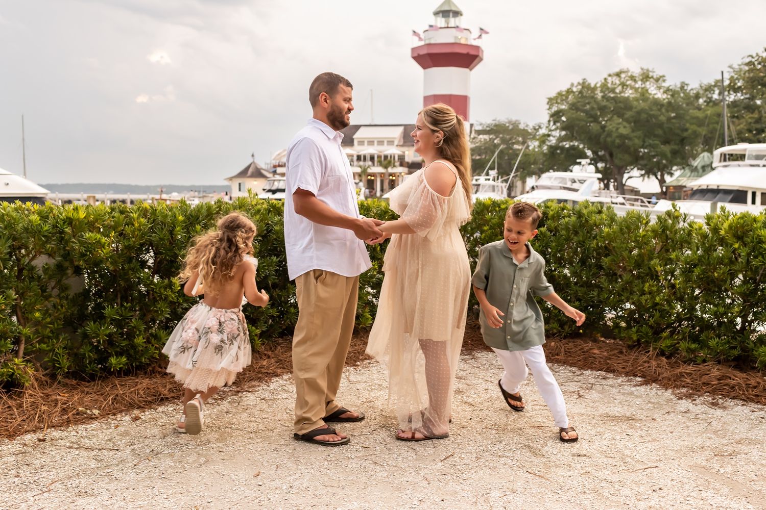 Family members walking together on a sandy beach path during a bright sunny day.