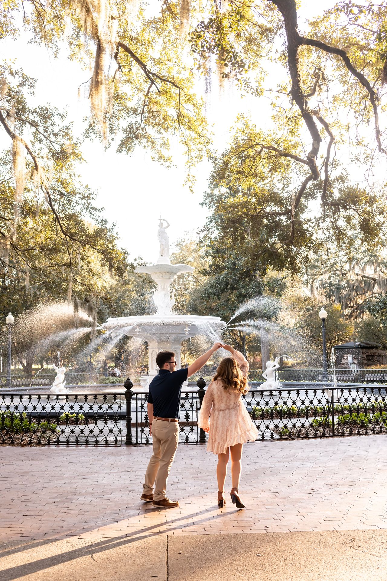 A romantic scene at the iconic Forsyth Park fountain in Savannah, Georgia on a golden autumn afternoon.