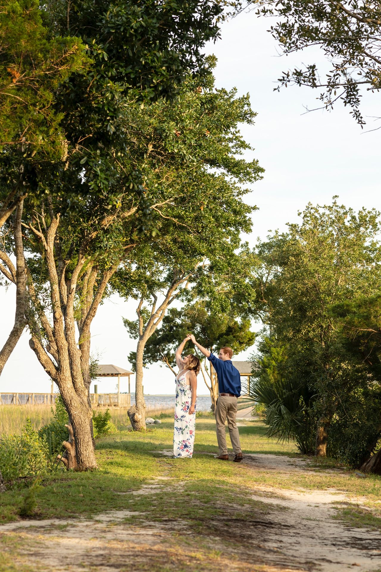 Progression of people swinging on a tree branch at a scenic outdoor location during golden hour lighting.