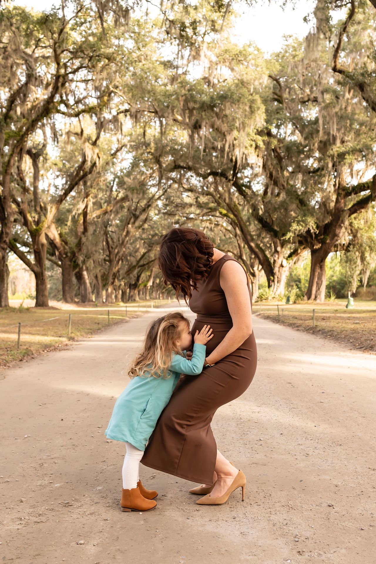 A heartwarming sequence of mother and child embracing on a tree-lined dirt path at sunset.