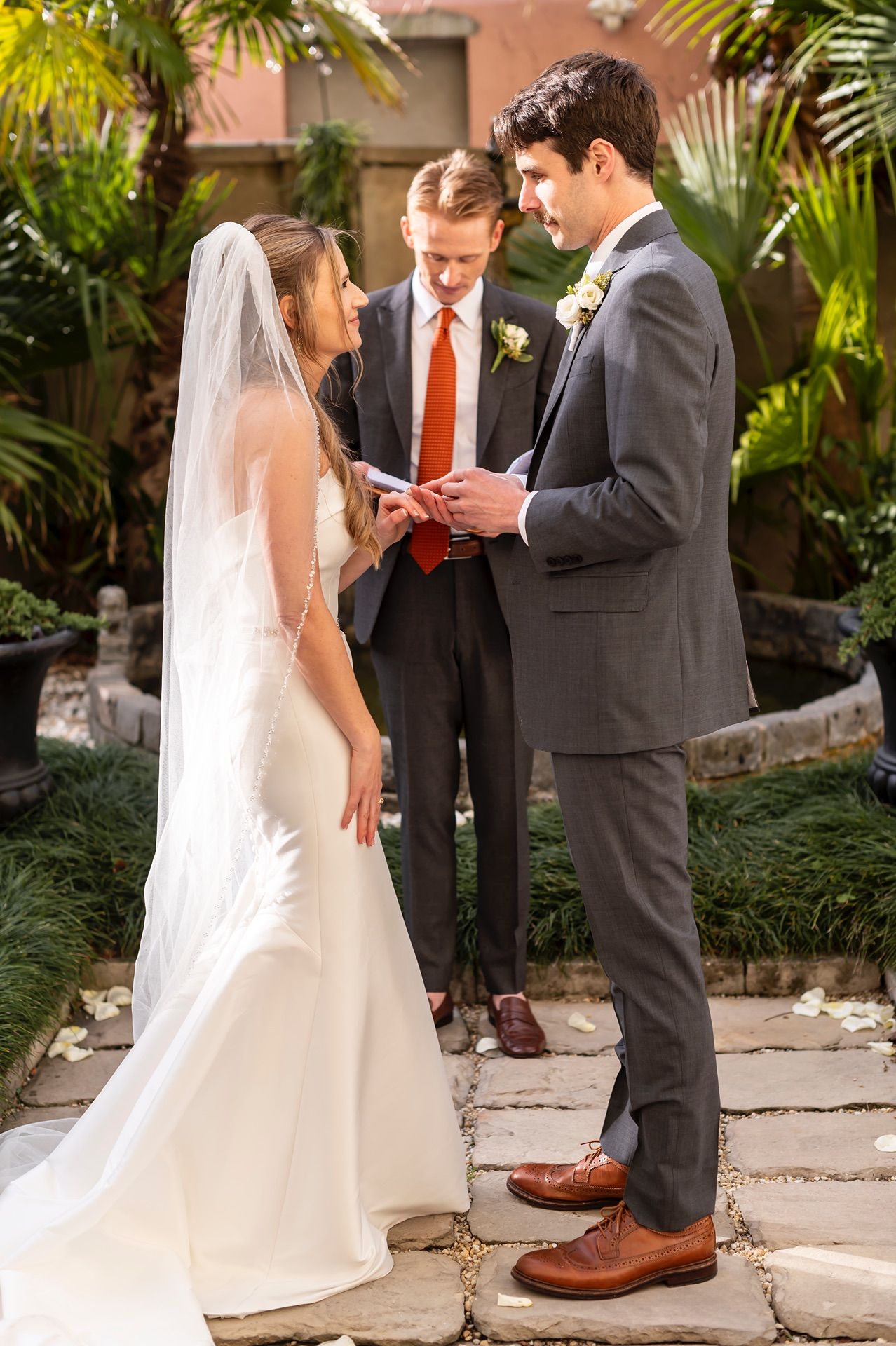 A series of wedding ceremony shots in a tropical garden setting shows a couple and officiant exchanging vows.