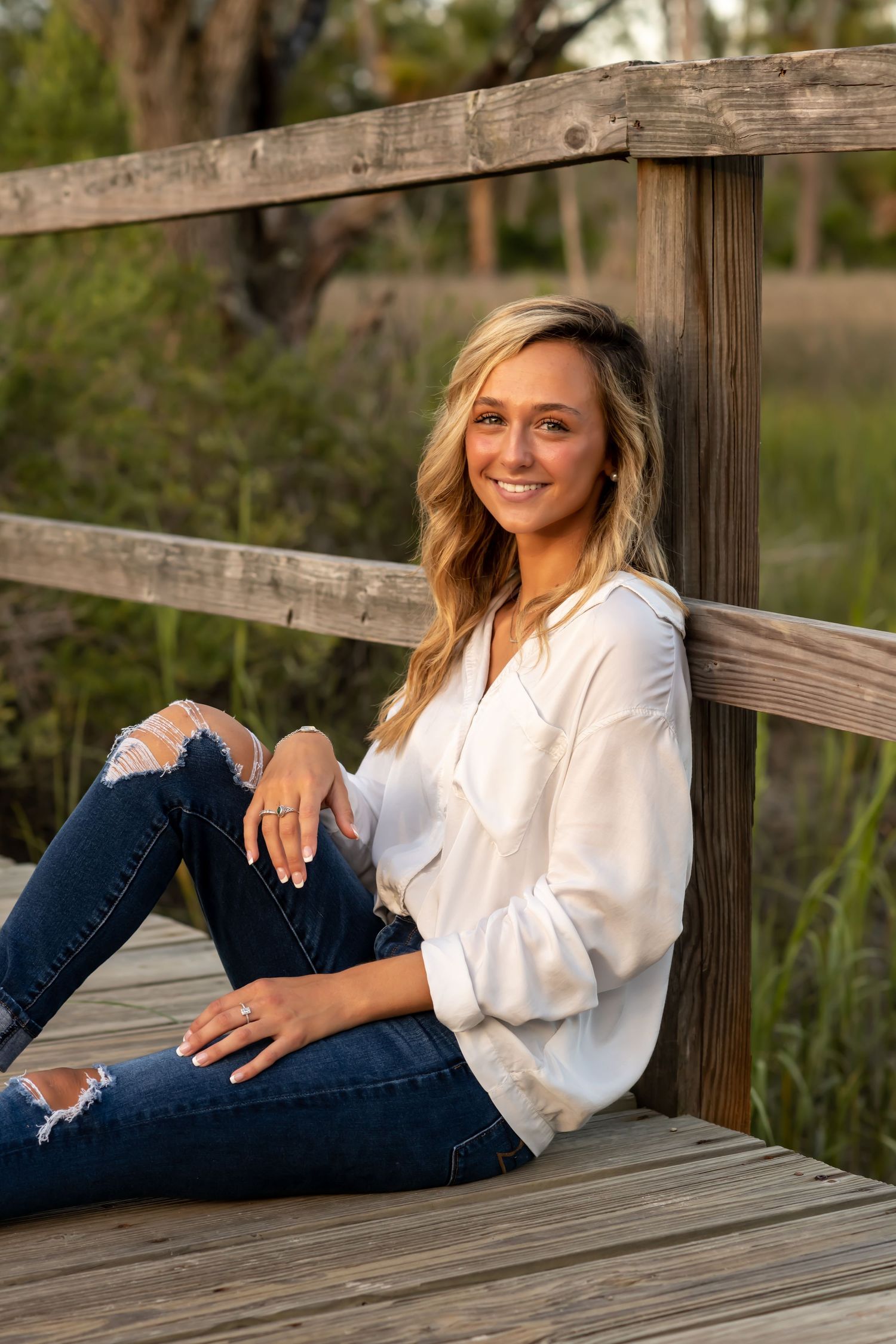 Casual portrait on wooden deck with natural background.