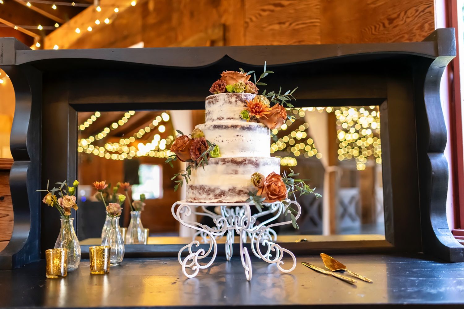 Wedding table settings with elegant floral centerpieces and twinkling lights create a romantic indoor reception atmosphere.