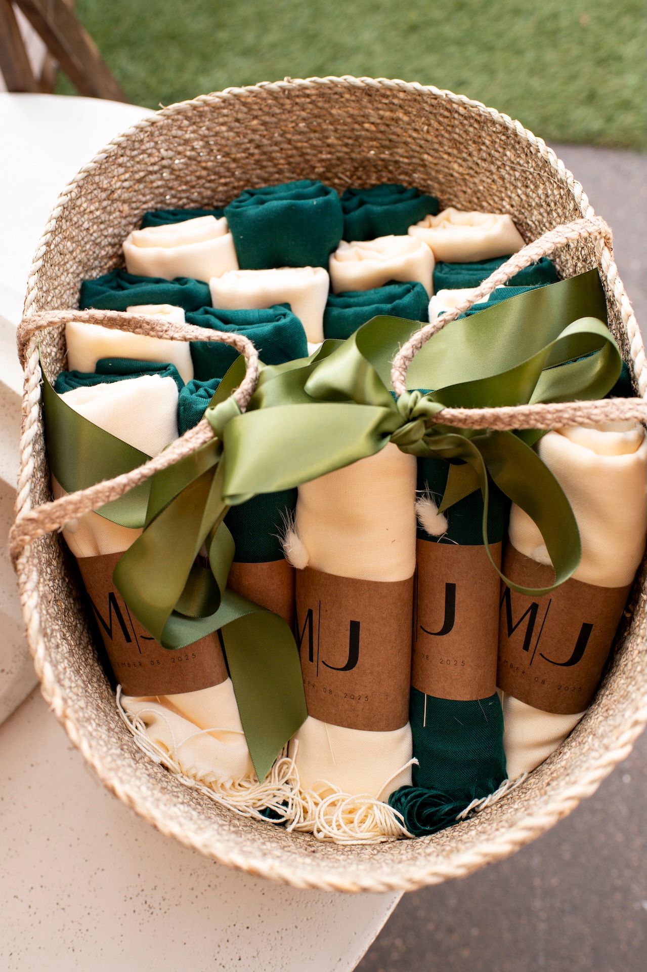 Decorative burlap basket filled with rolled paper scrolls tied with green and beige ribbons arranged in a circular pattern.