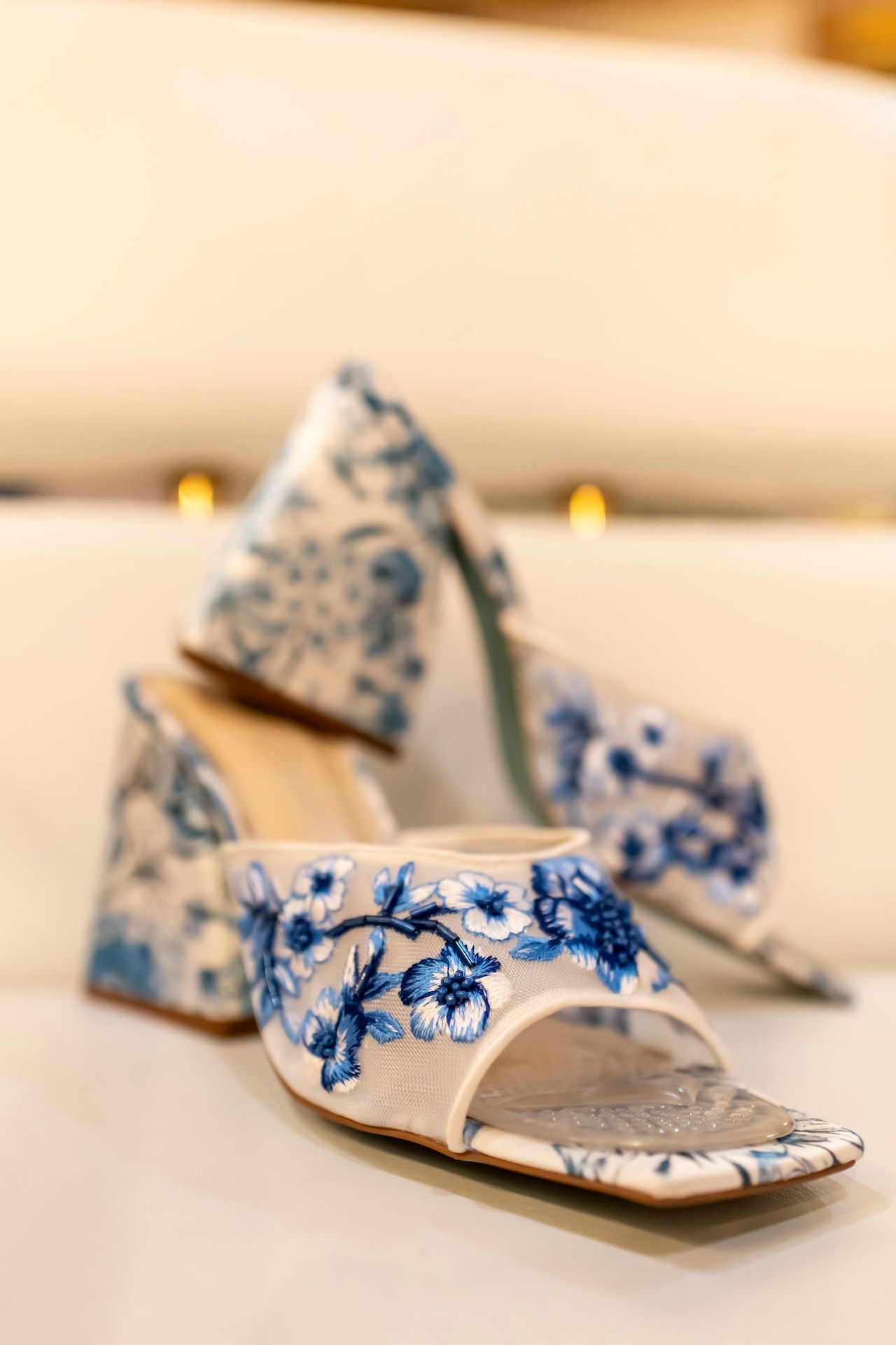 Delicate white and blue floral sandals arranged in a progression shot showing different angles.