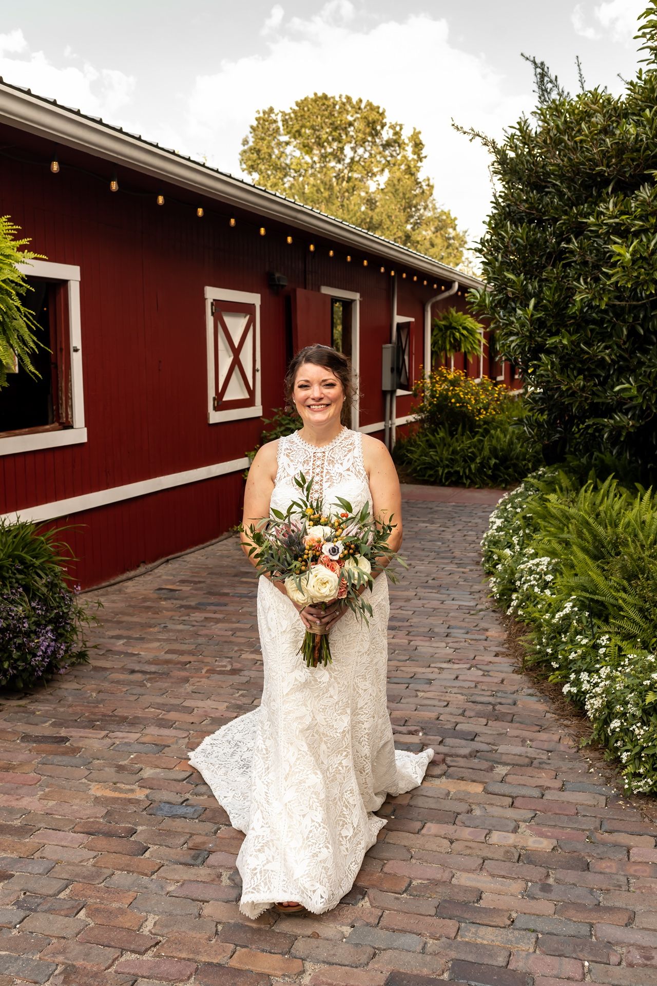Series of photos showing a bridal portrait session outside a red barn with white trim and brick pathway.
