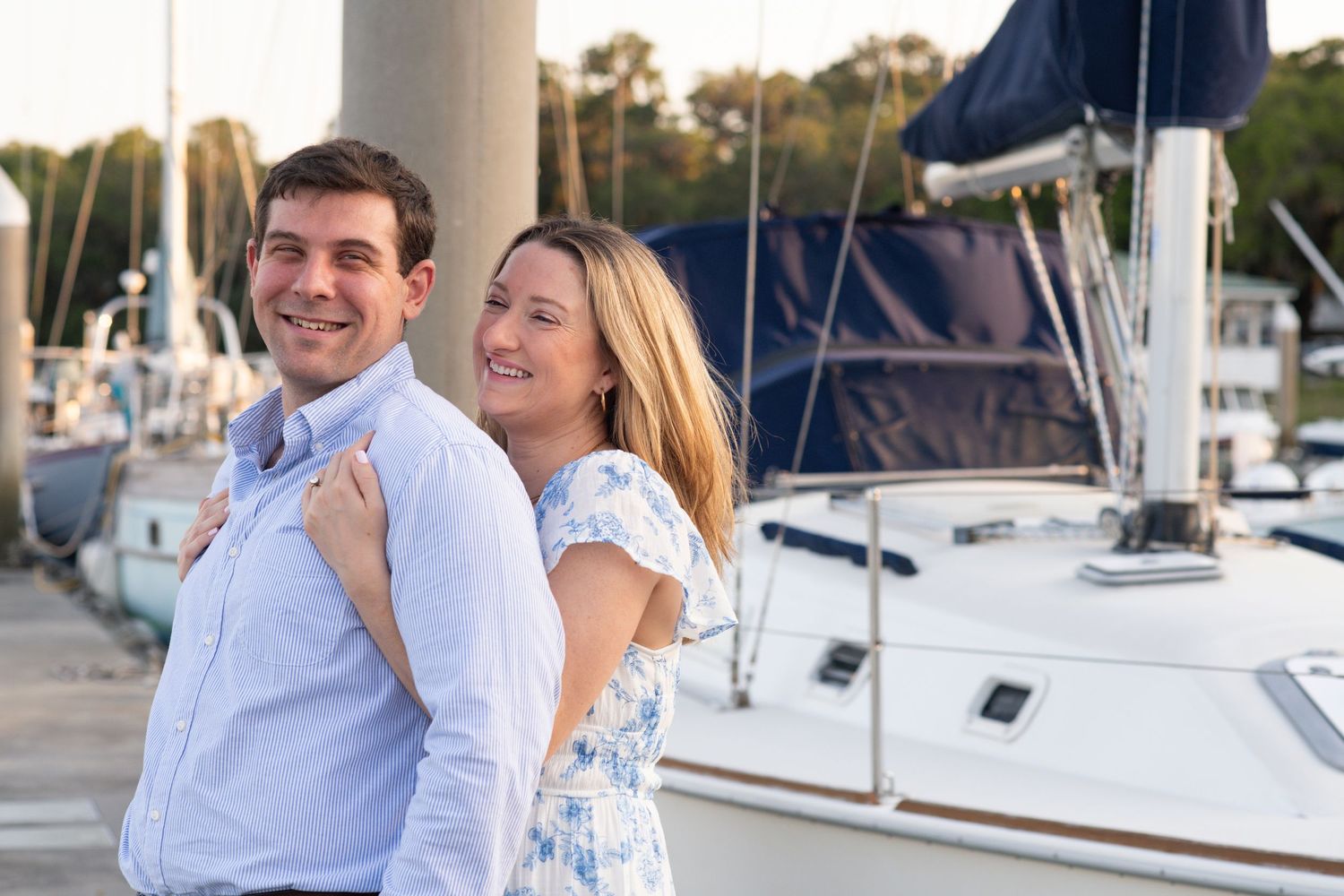 Happy couple enjoying a romantic sunset moment together on a sailboat at the marina.