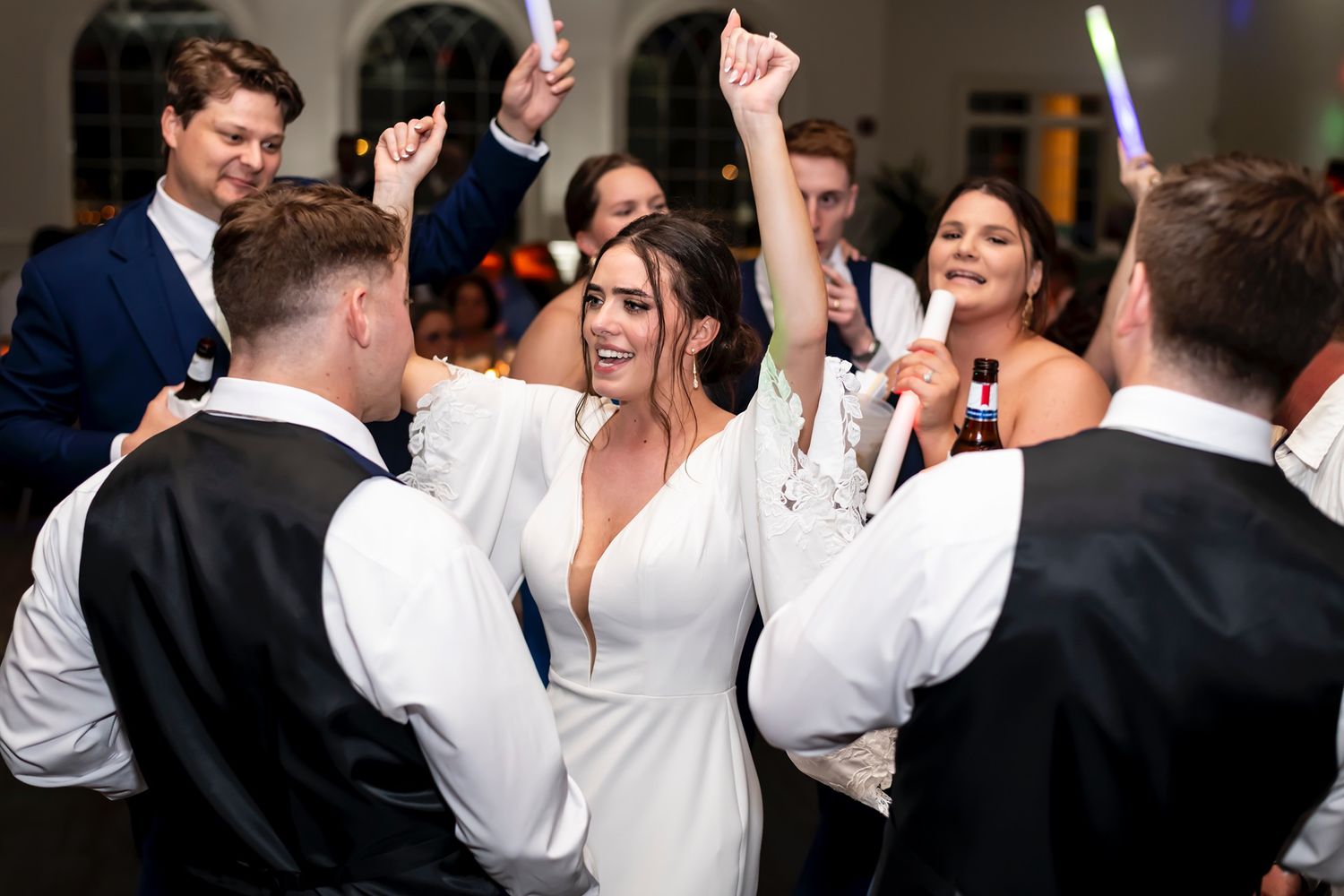 Wedding party dances and celebrates on the dance floor during a reception party.
