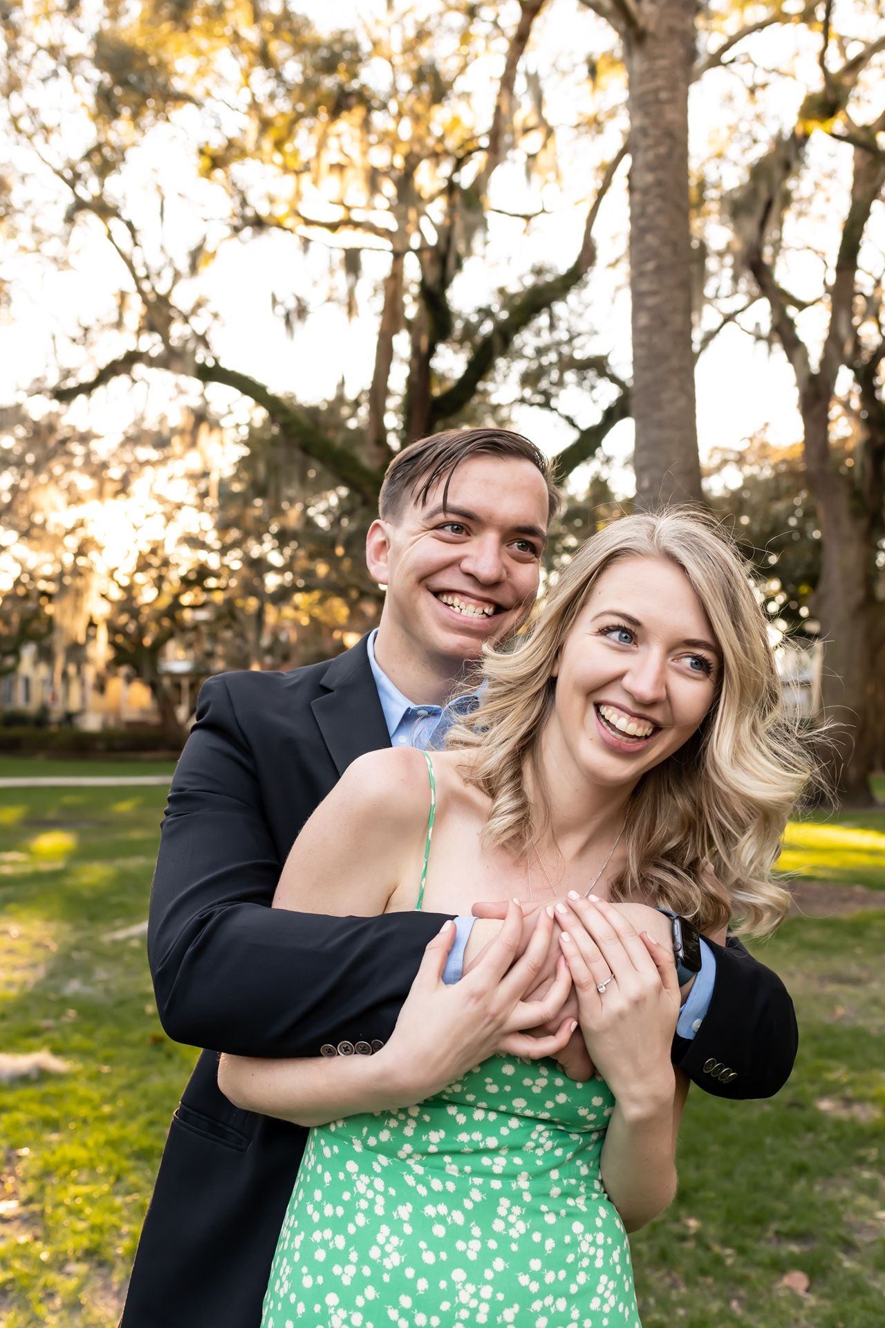 A playful outdoor photo sequence in a park setting with a couple wearing black and green polka dot dress.