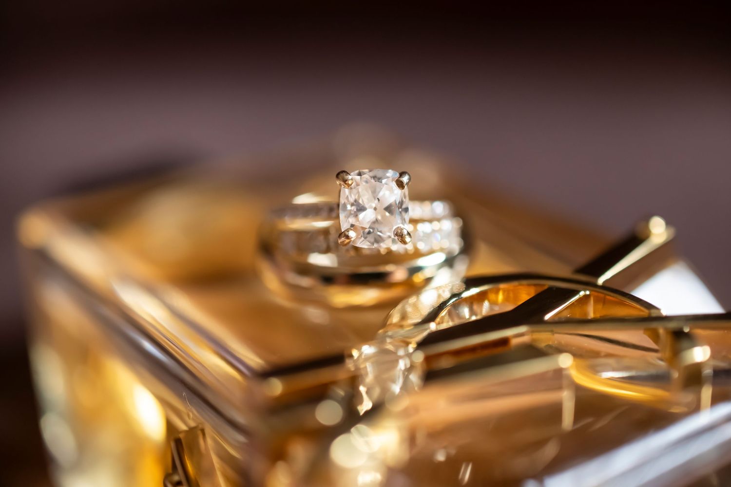 Close-up of golden wedding rings and jewelry details in dramatic lighting.