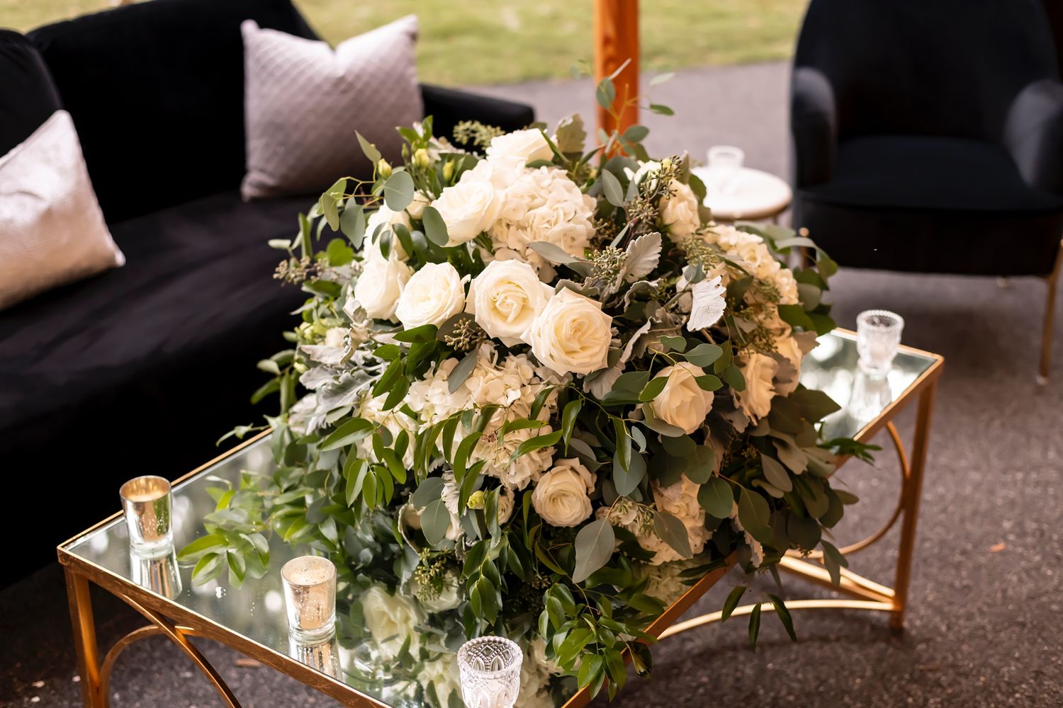 Elegant floral arrangements with white roses and greenery decorate formal dining tables.