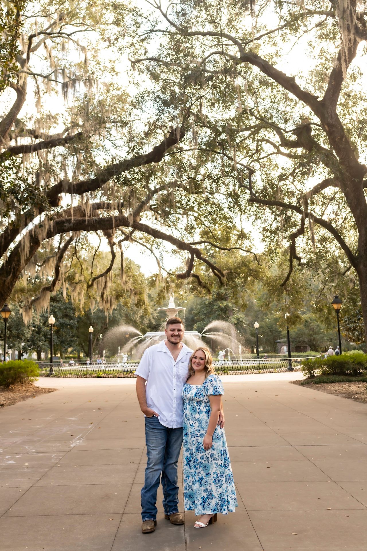 A joyful celebration moment captured in a sunlit park with oak trees.
