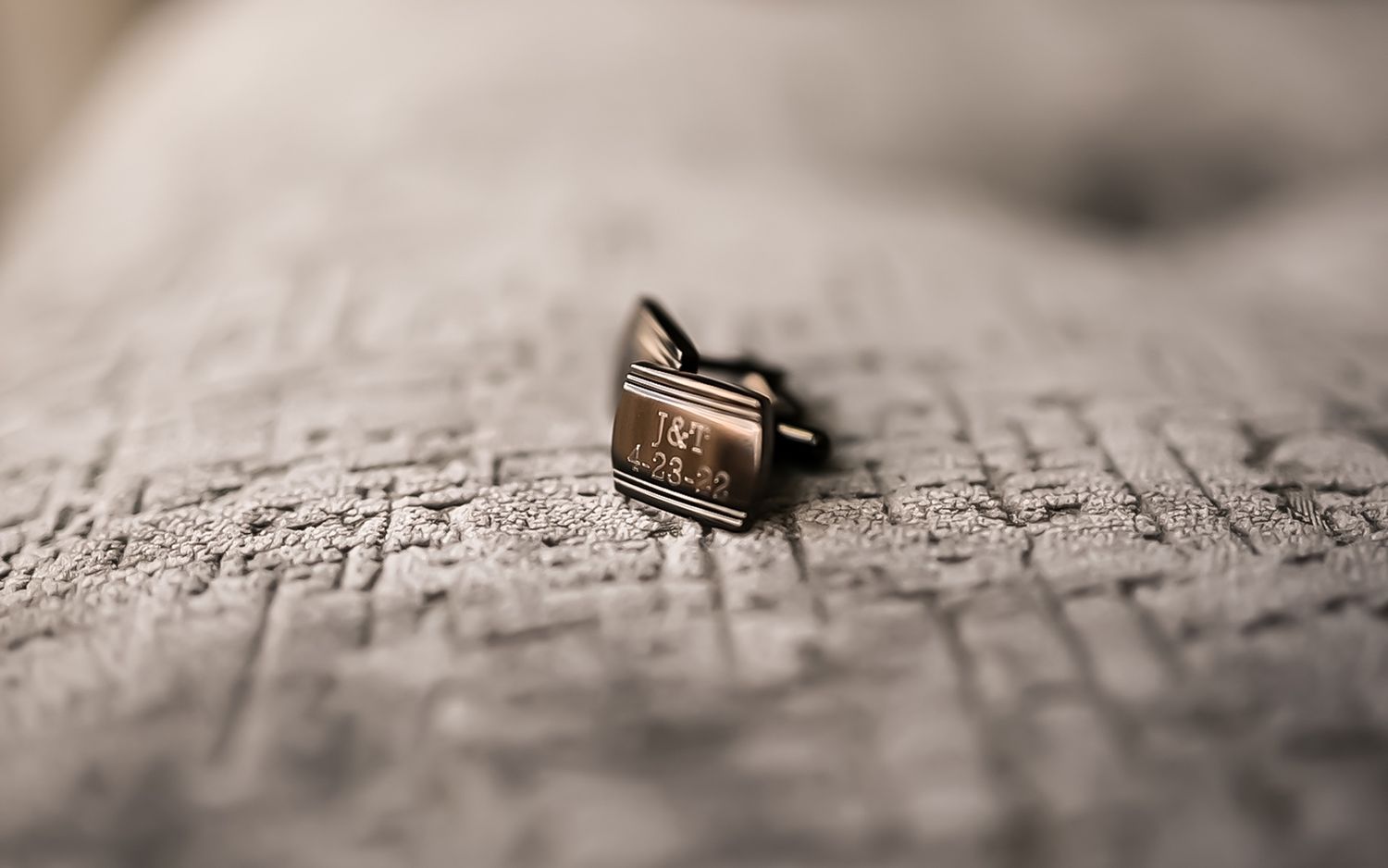 A vintage golden ring rests on weathered book pages with shallow depth of field creating a romantic mood.