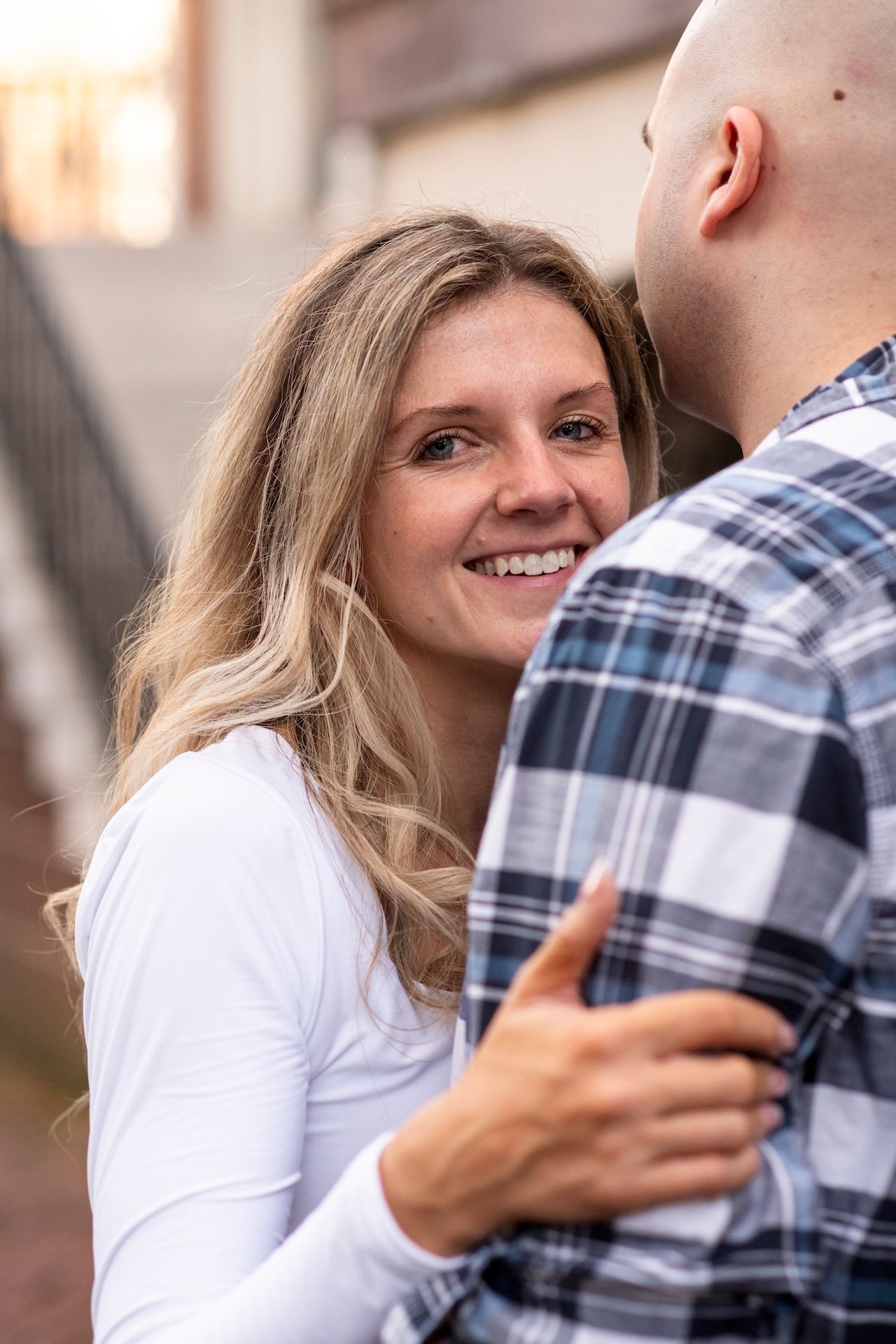Close-up shots of a couple embracing and smiling in white and plaid clothing outdoors.