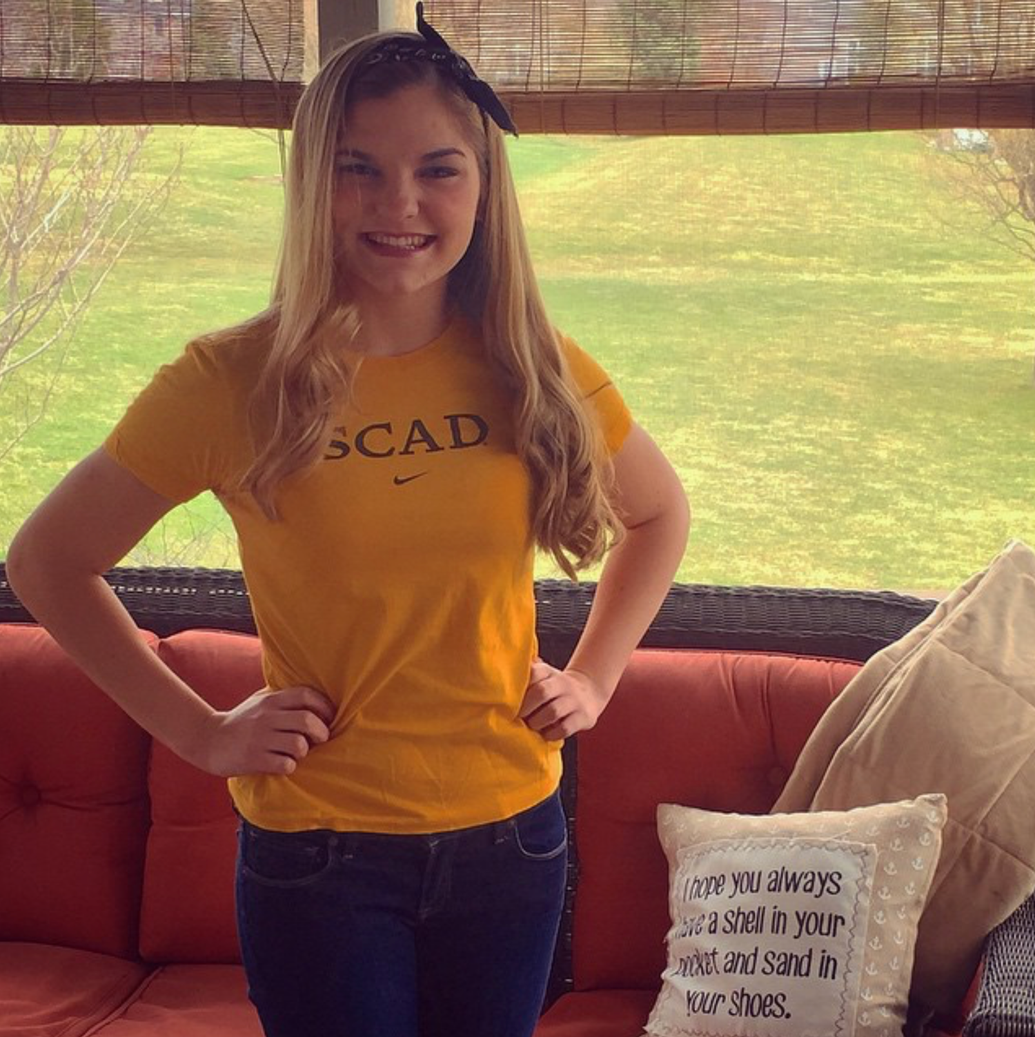 Student wearing yellow SCAD t-shirt poses on red couch in multiple candid shots showing different relaxed expressions.