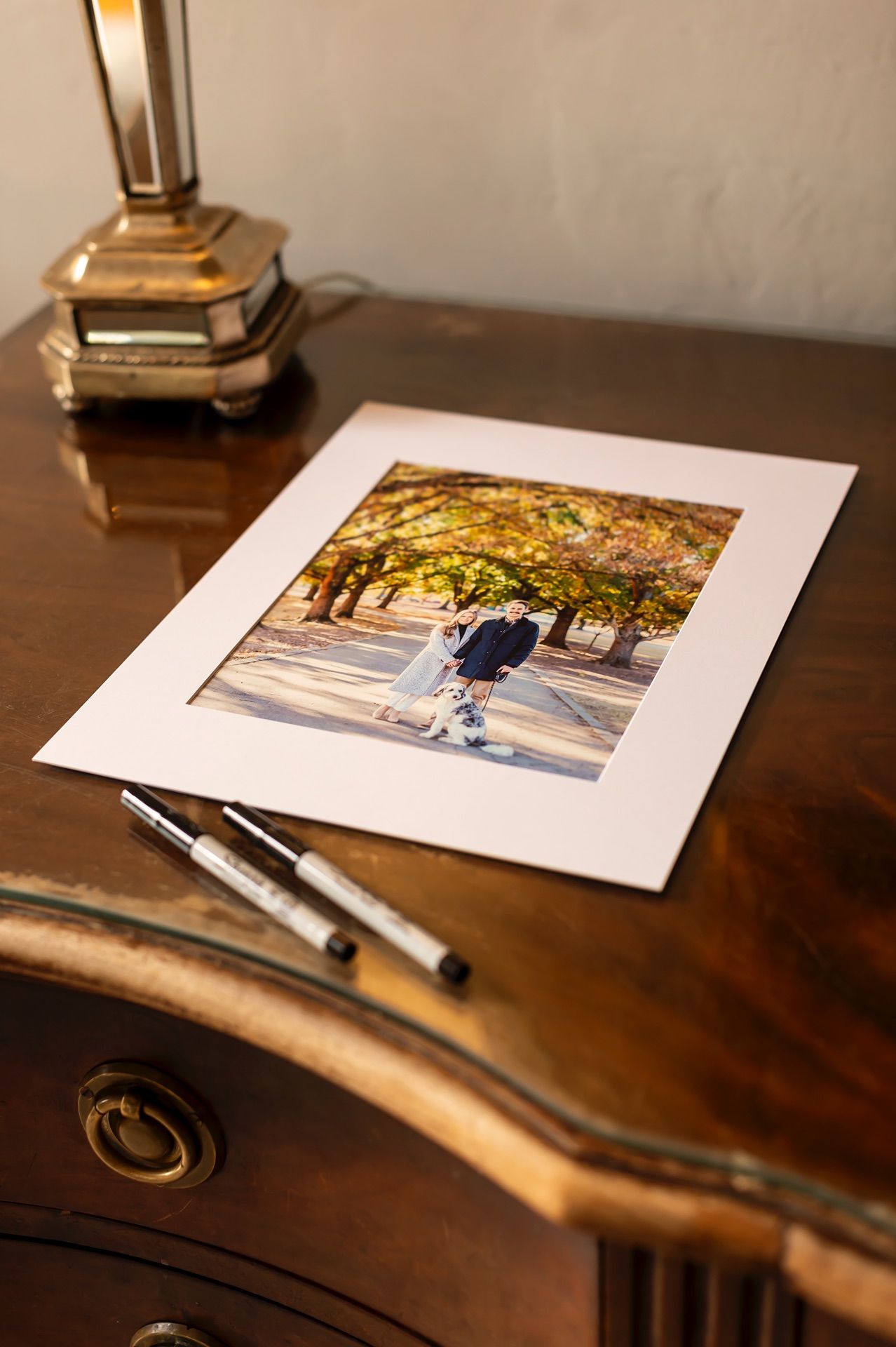 Four photographs displayed on a rustic wooden surface with markers create an artistic composition with warm lighting.
