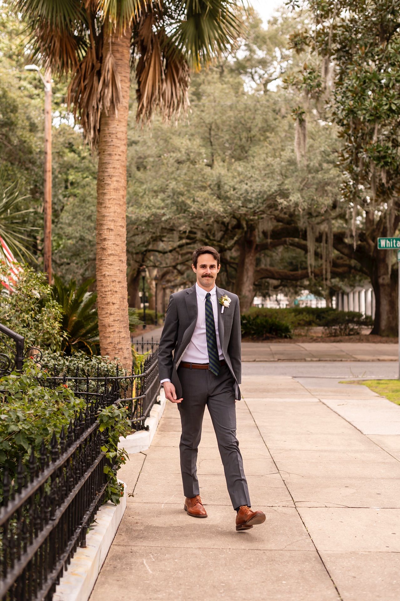 A sequence of photos shows a suited figure walking alongside a palm tree lined sidewalk on a sunny day.