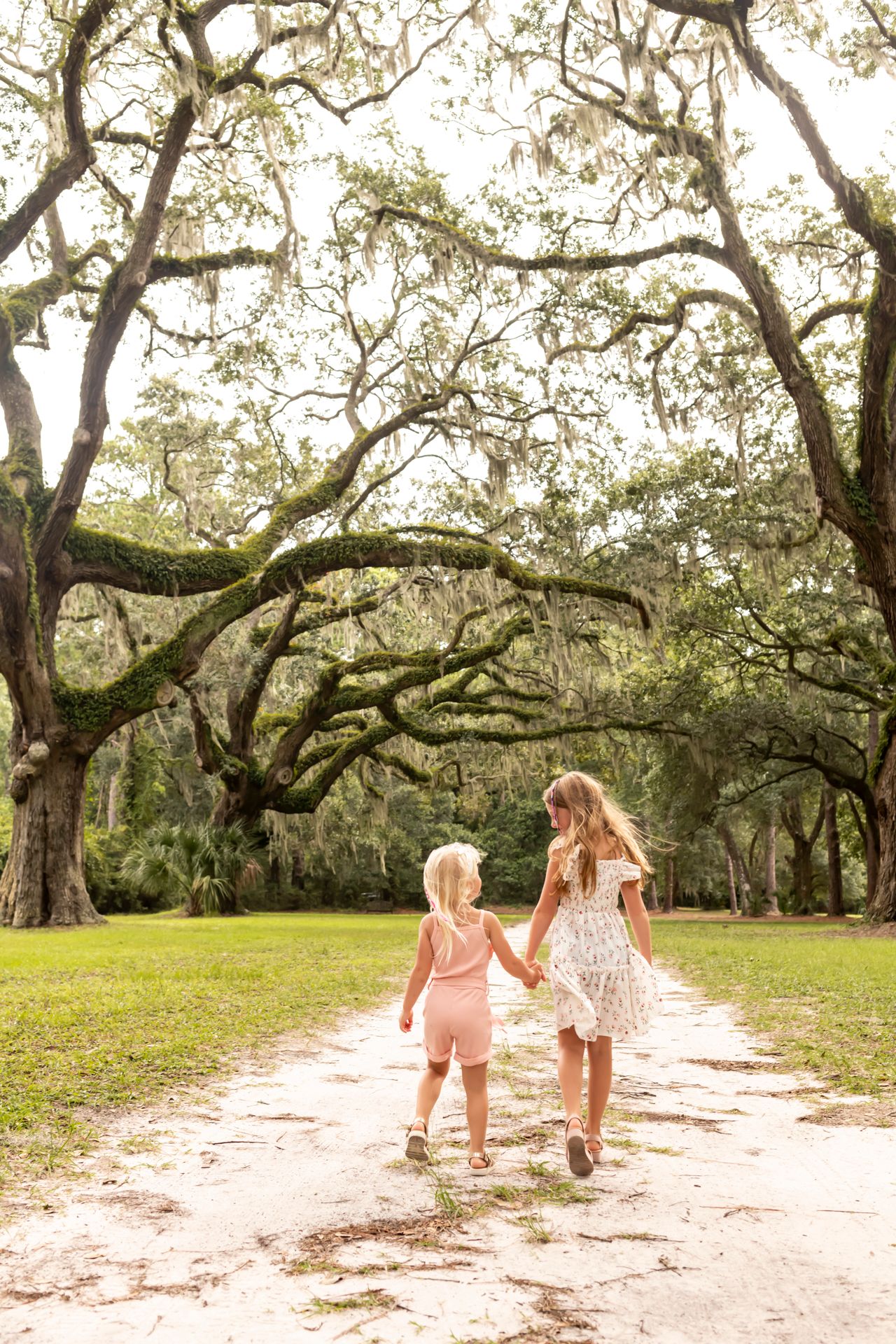Candid sisters portrait at Six Oaks moss-covered pathway