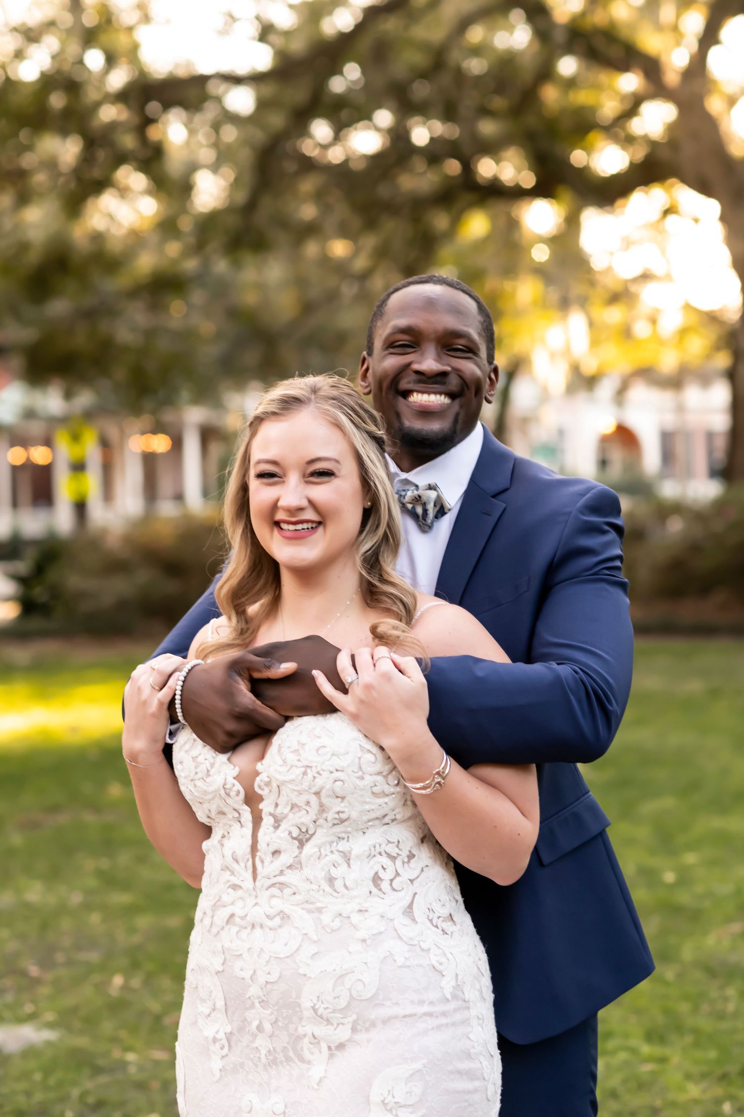 Newlywed couple sharing joyful embrace outdoors with sunny evening lighting.