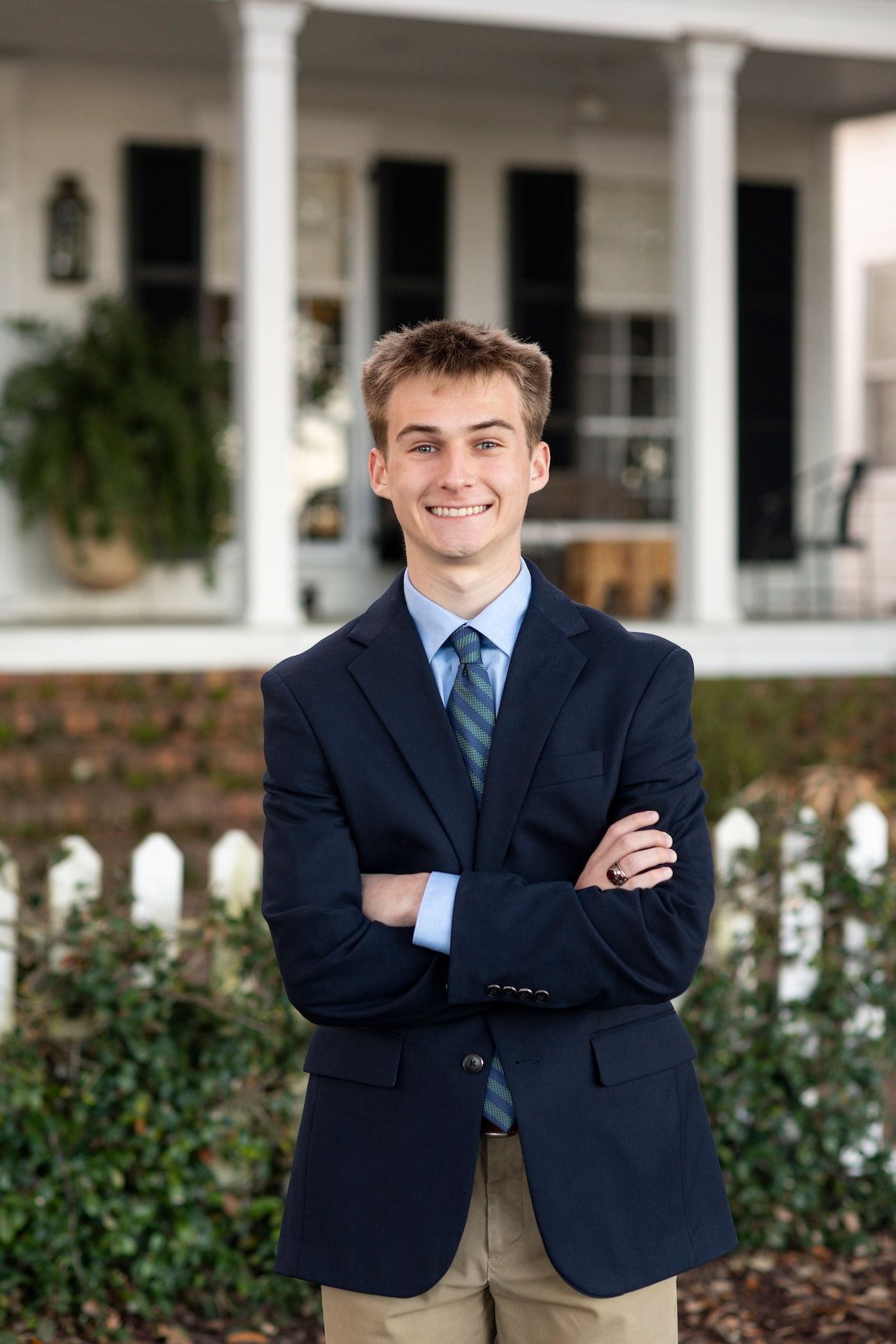 A senior posing in front of a home for senior portraits in Isle of Hope.
