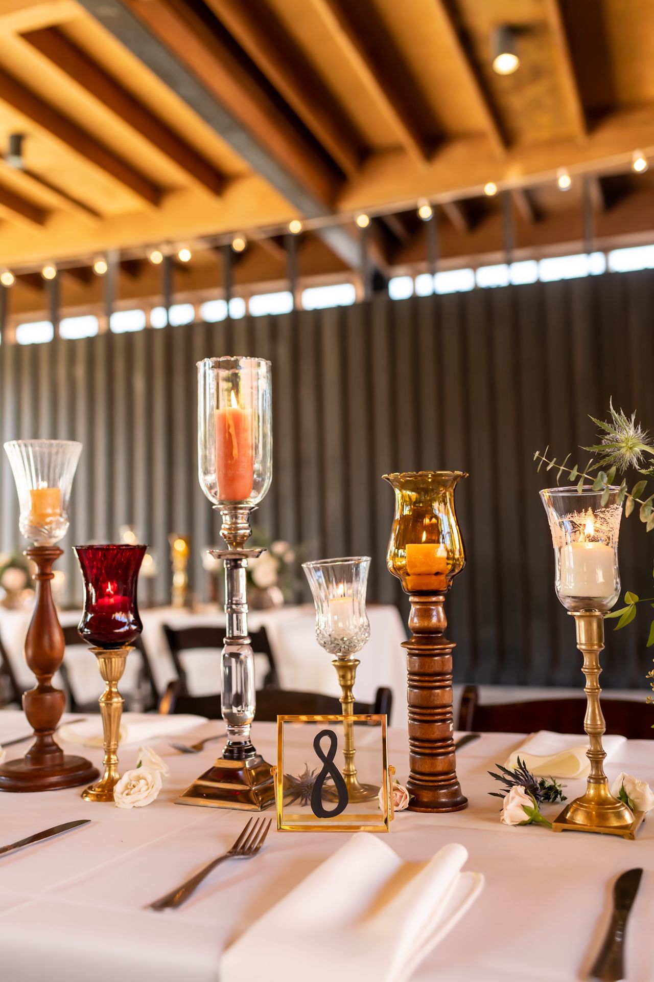Elegant table settings with vintage candelabras, glassware, and place settings in a rustic restaurant interior.