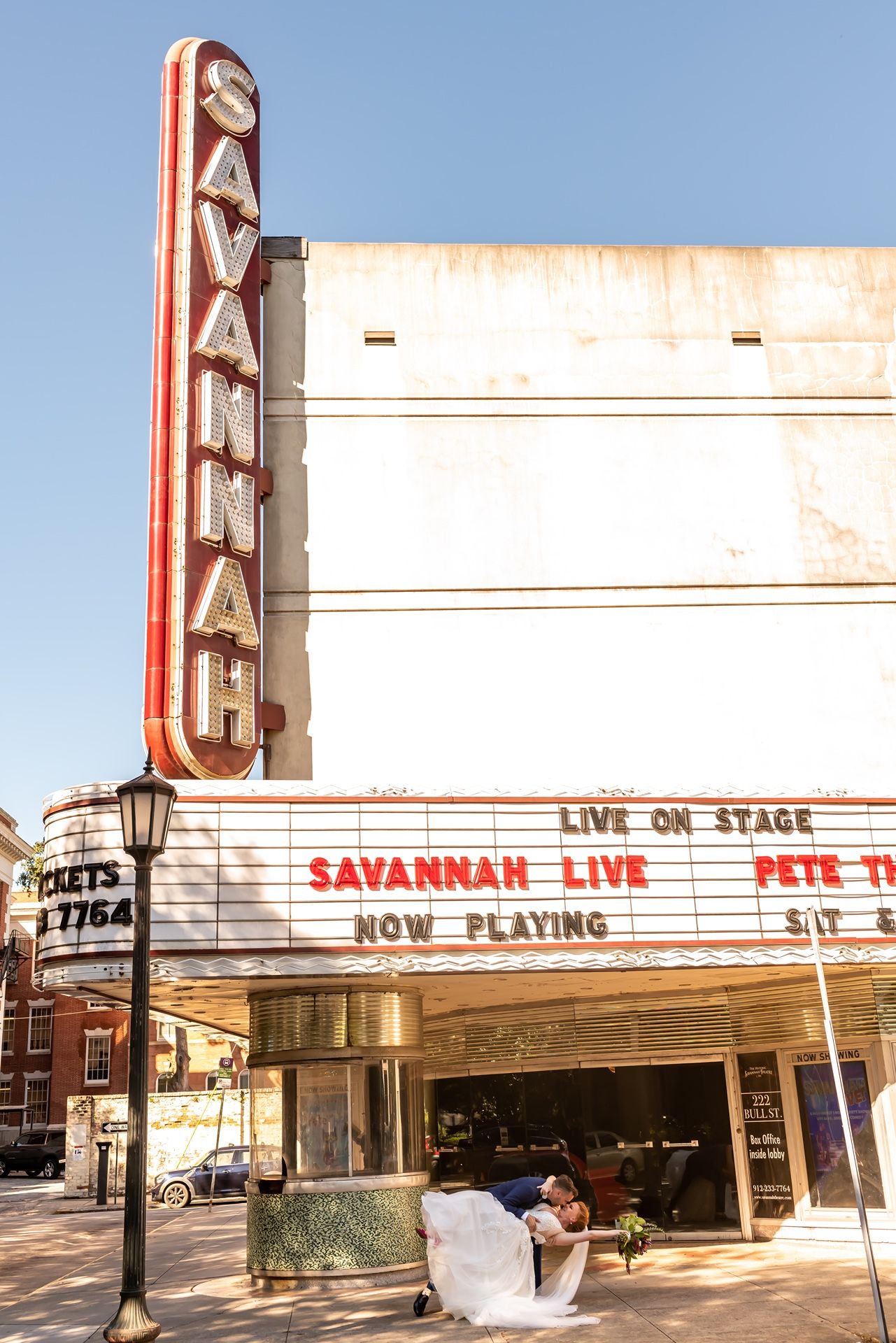 Vintage Savannah Theatre marquee displaying 'Savannah Live' on a sunny day with historic architecture and street signs.